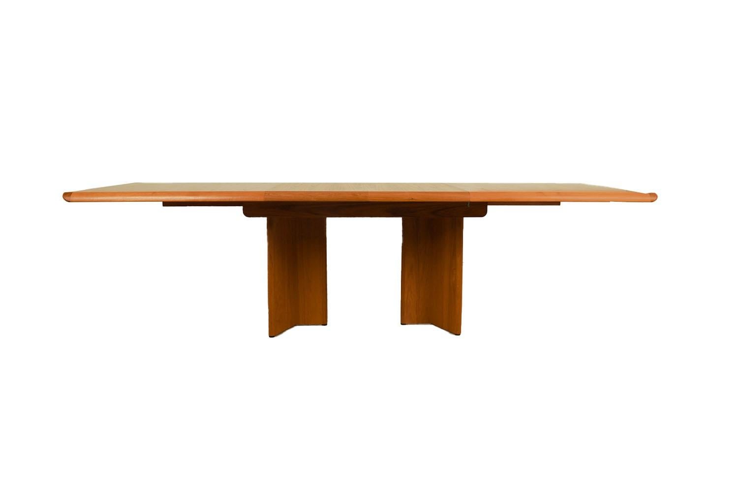 Beautiful Mid-Century Modern expandable dining table, by Henning Kjærnullf for Vejle Støle & Møbelfabrik, 1960's. Featuring richly grained, gleaming teak and smooth, clean lines characteristic of classic Danish design. This remarkable dining table