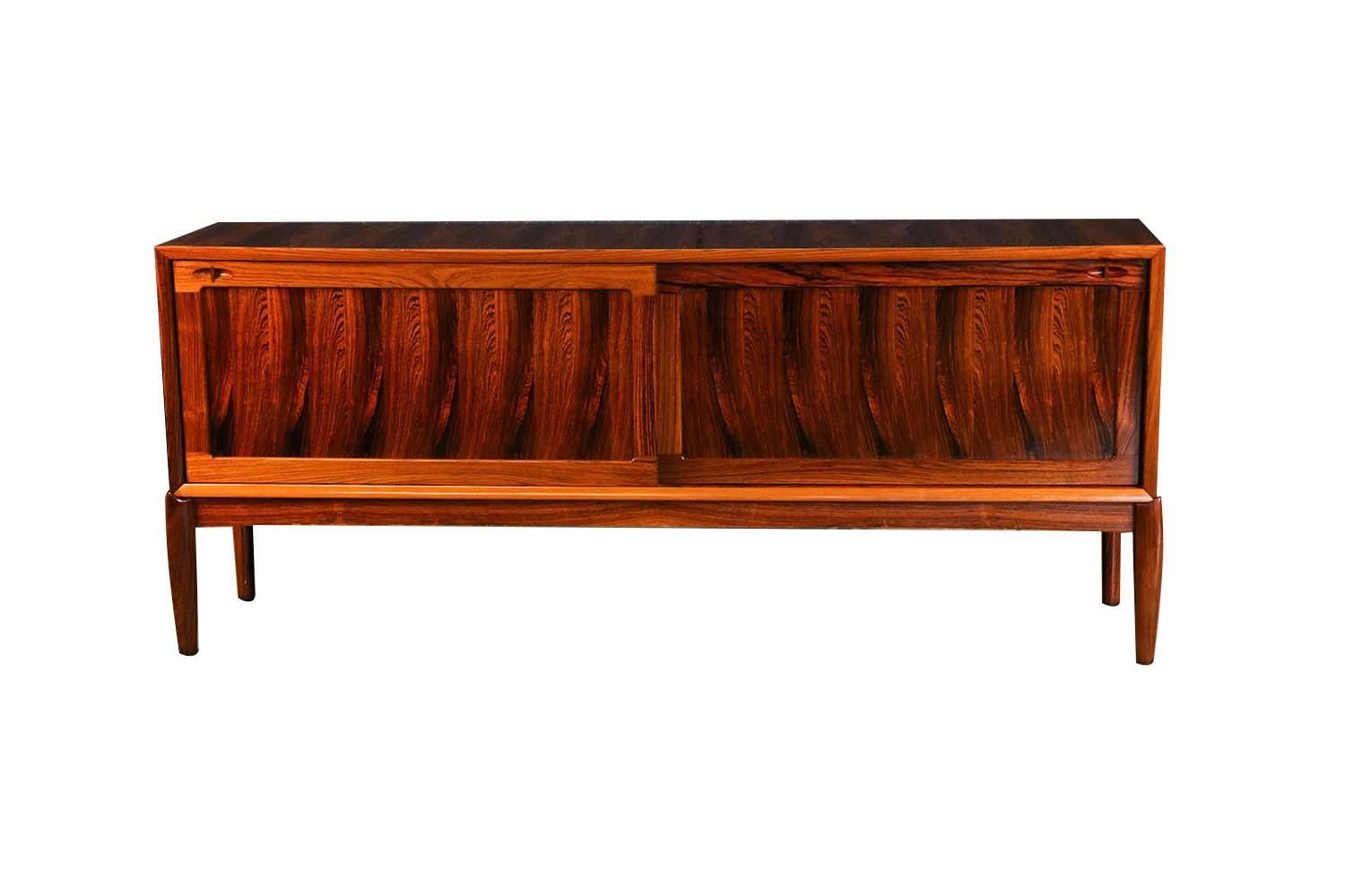 Vintage Danish designed Henry Walter Klein sideboard in Brazilian Rosewood for Bramin. A magnificent, rare, Danish designed sideboard by H.W. Klein featuring two large sliding doors that open to reveal two bays outfitted with a fitted rosewood