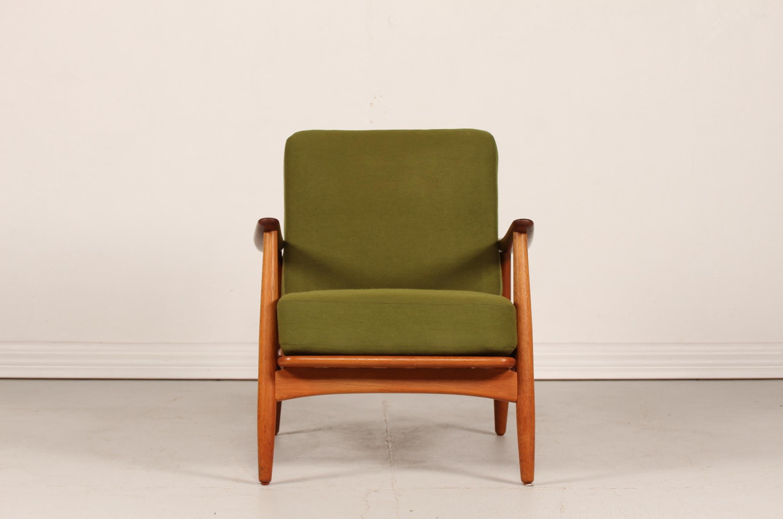 Easy chair model 121 after Johannes Andersens design (1903-1995) made by Københavns Madrasfabrik.
The frame is made of oak with teak armrests and the old and original cushions are upholstered with green fabric.