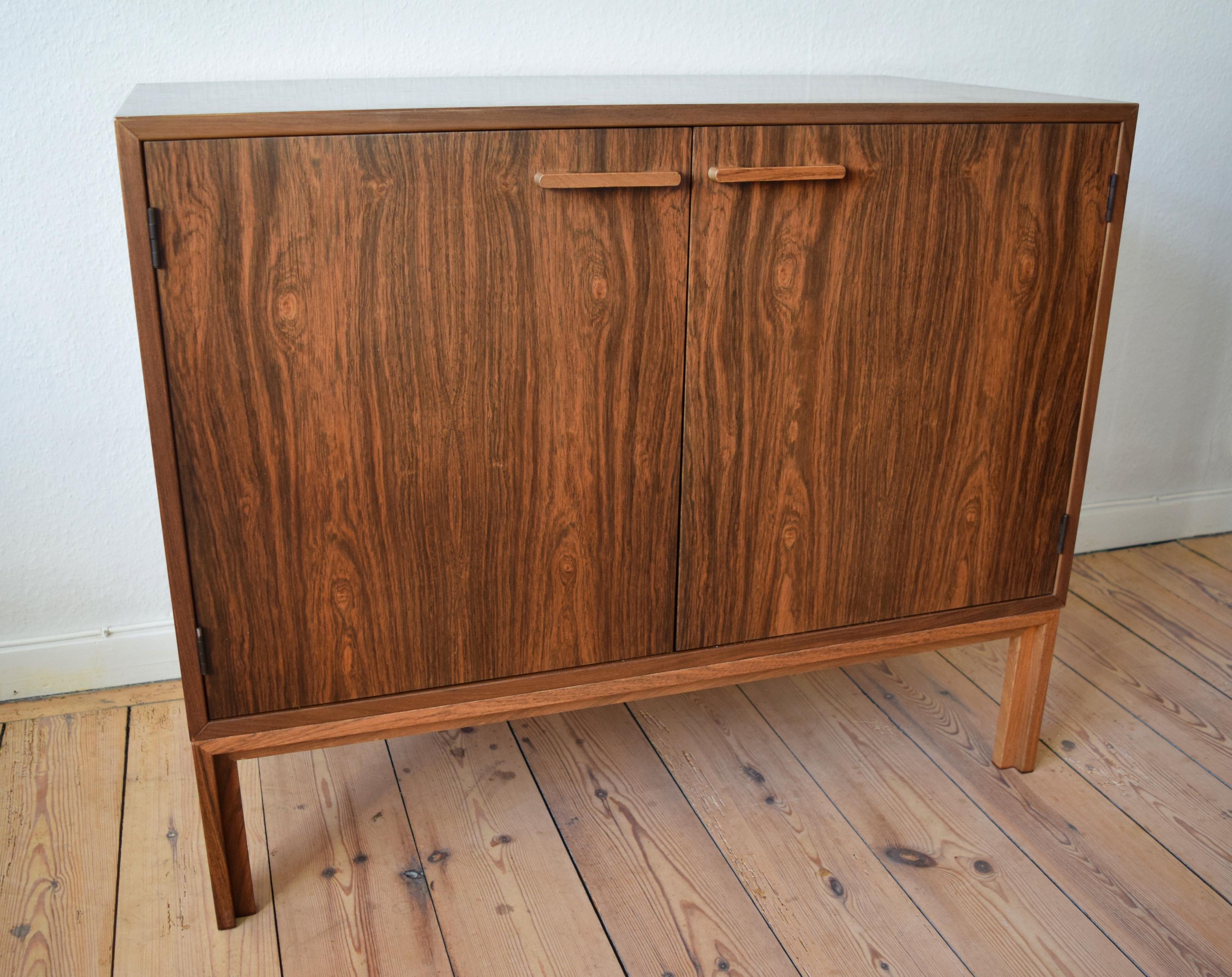 Danish rosewood cabinet by Kai Kristiansen for FM Møbler. Manufactured in the 1960s, this piece features two doors with adjustable internal shelf and felt-lined rosewood drawer. Sits on frame base solid rosewood legs. Striking rosewood grain inside