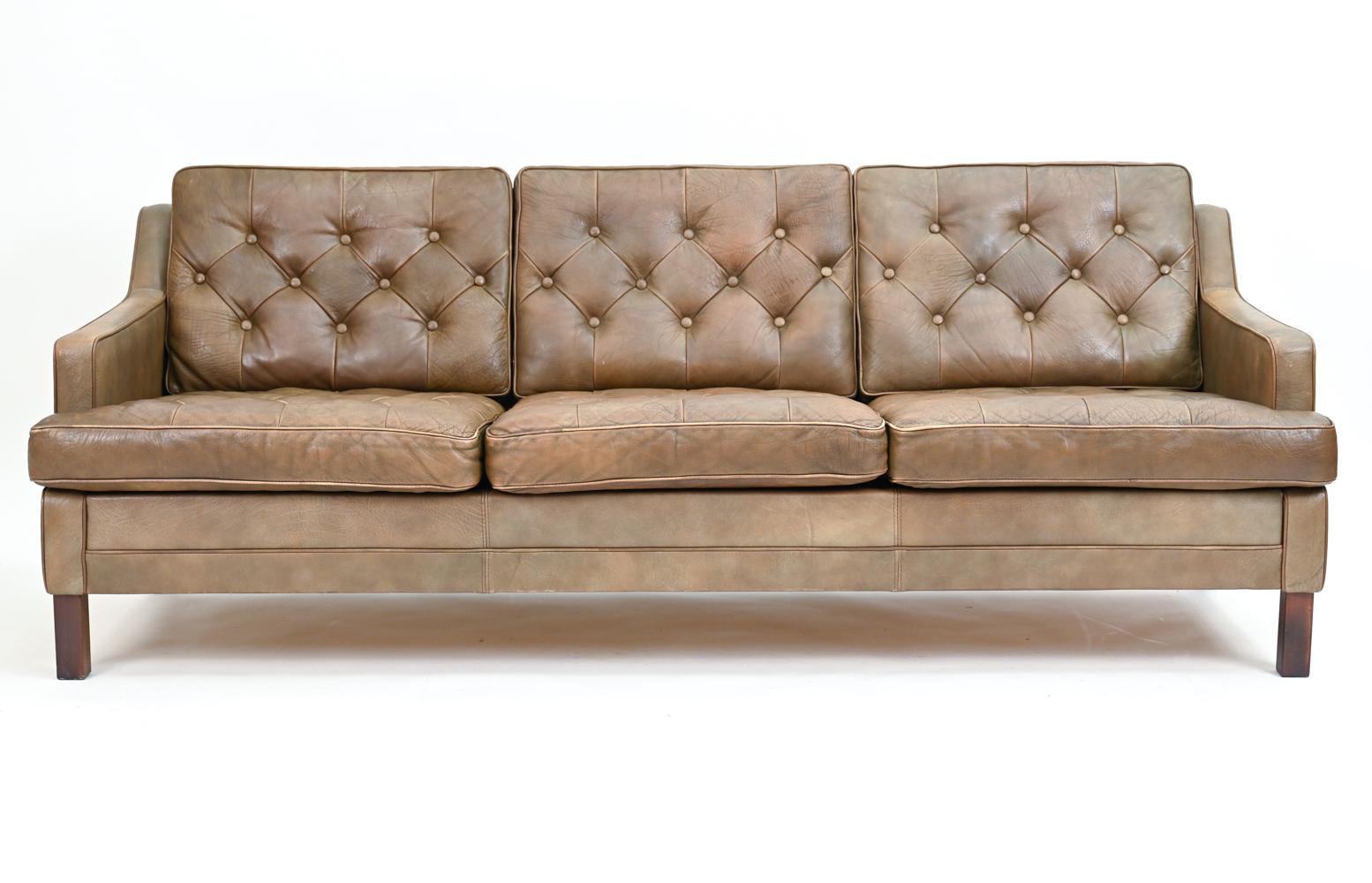 A fabulous Danish mid-century button-tufted three-seater sofa in supple brown leather, in the manner of Arne Norell's iconic 
