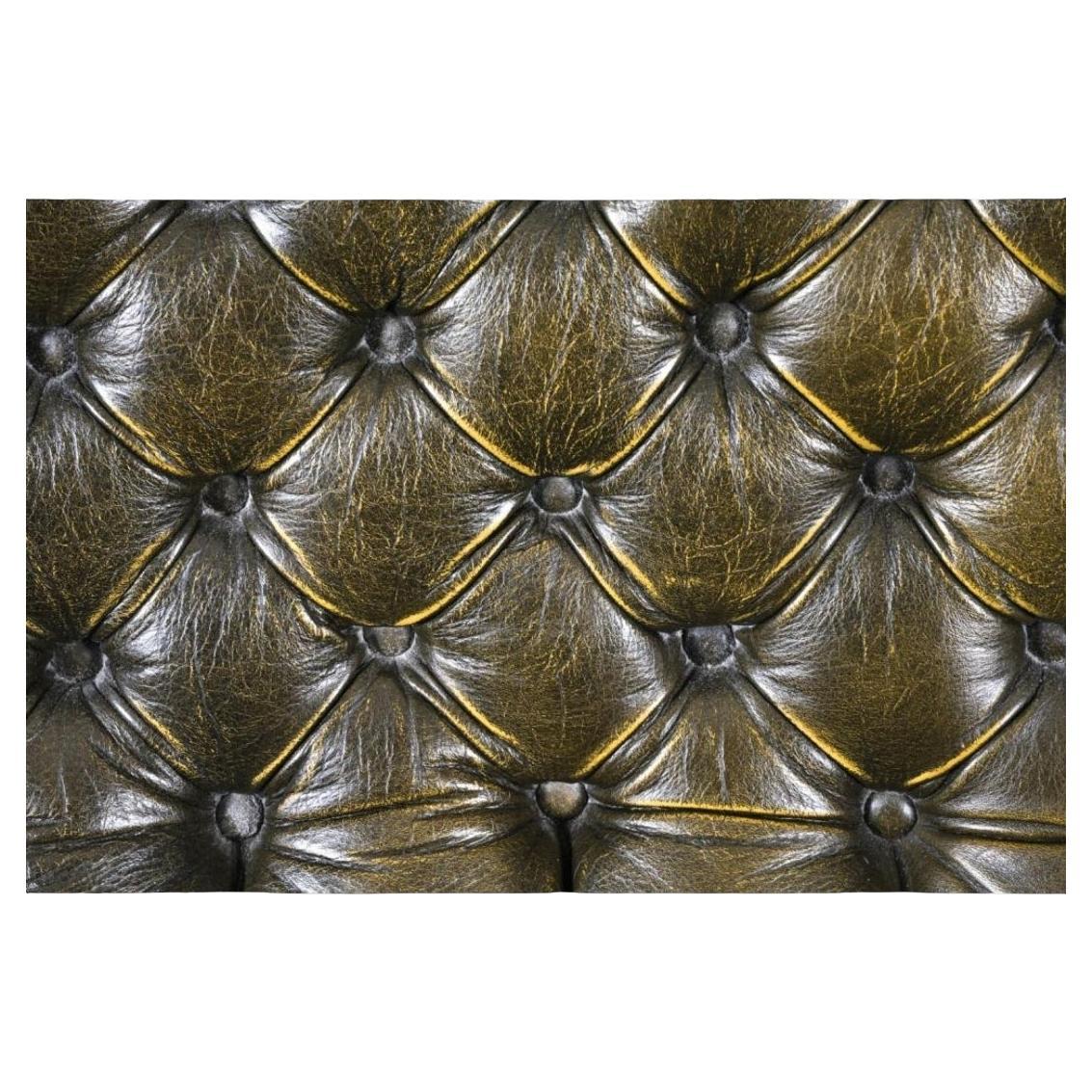 Chaise à oreilles en cuir tufté et boutonné de style Chesterfield et ottoman assorti. Cette chaise présente des accoudoirs légèrement chantournés aux silhouettes austères et raffinées. Il est fini en cuir travaillé avec une patine douce que seules