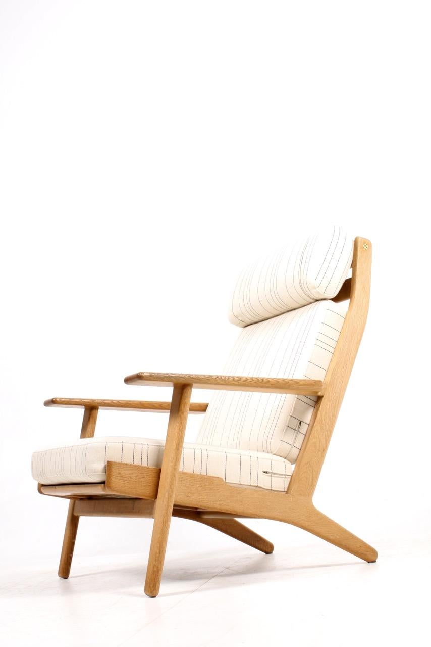 This Danish GE 290 easy chair was designed by Hans J. Wegner and produced by GETAMA during the 1960s. The frame is made in solid oak and fabric cushions.