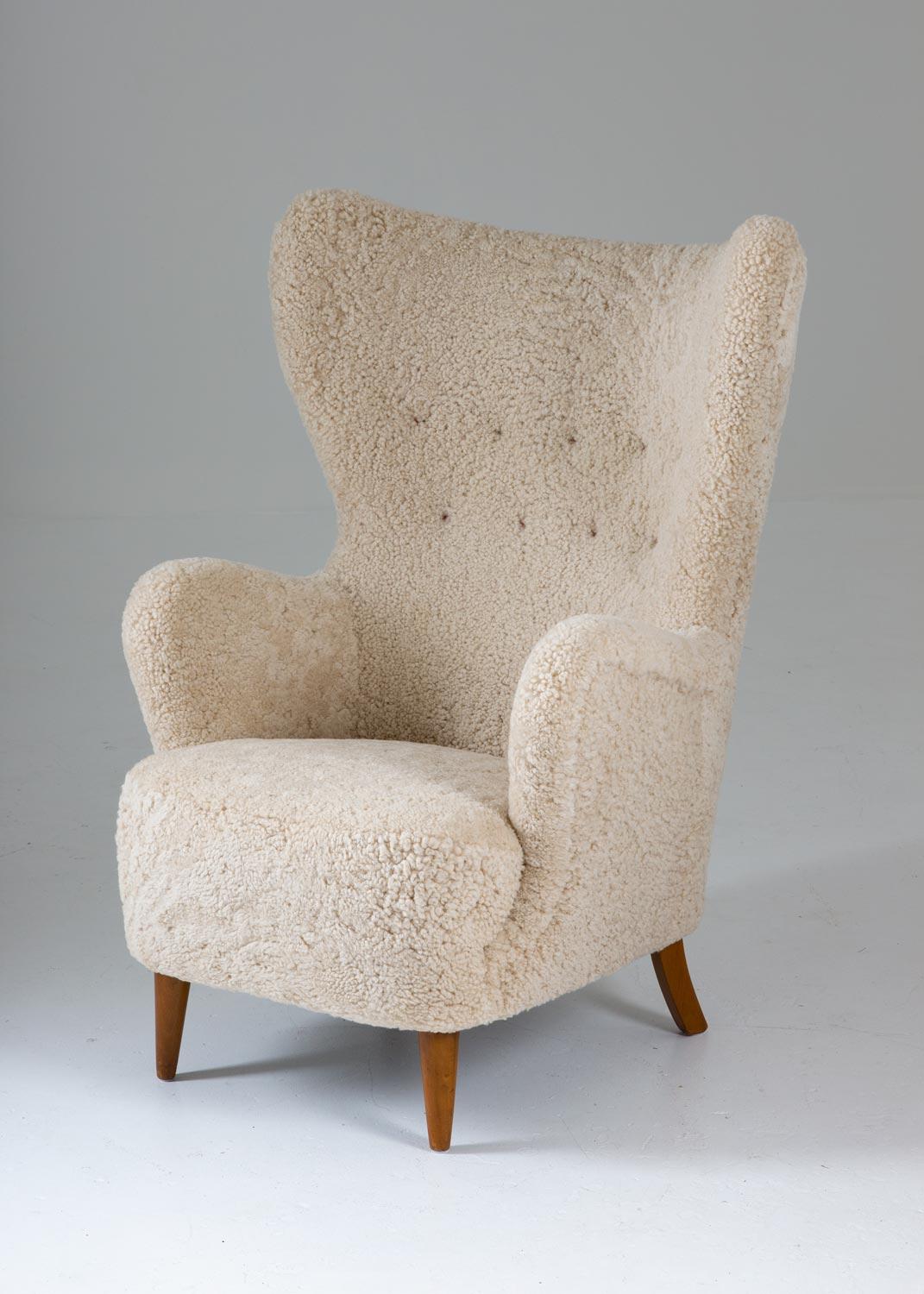 Sculptural high back wing chair manufactured in Denmark, circa 1940. 
This majestic chair looks great from any angle with its harmonic expressions. On top of that, it is as comfortable as it looks. It's been upholstered in honey-white sheepskin and