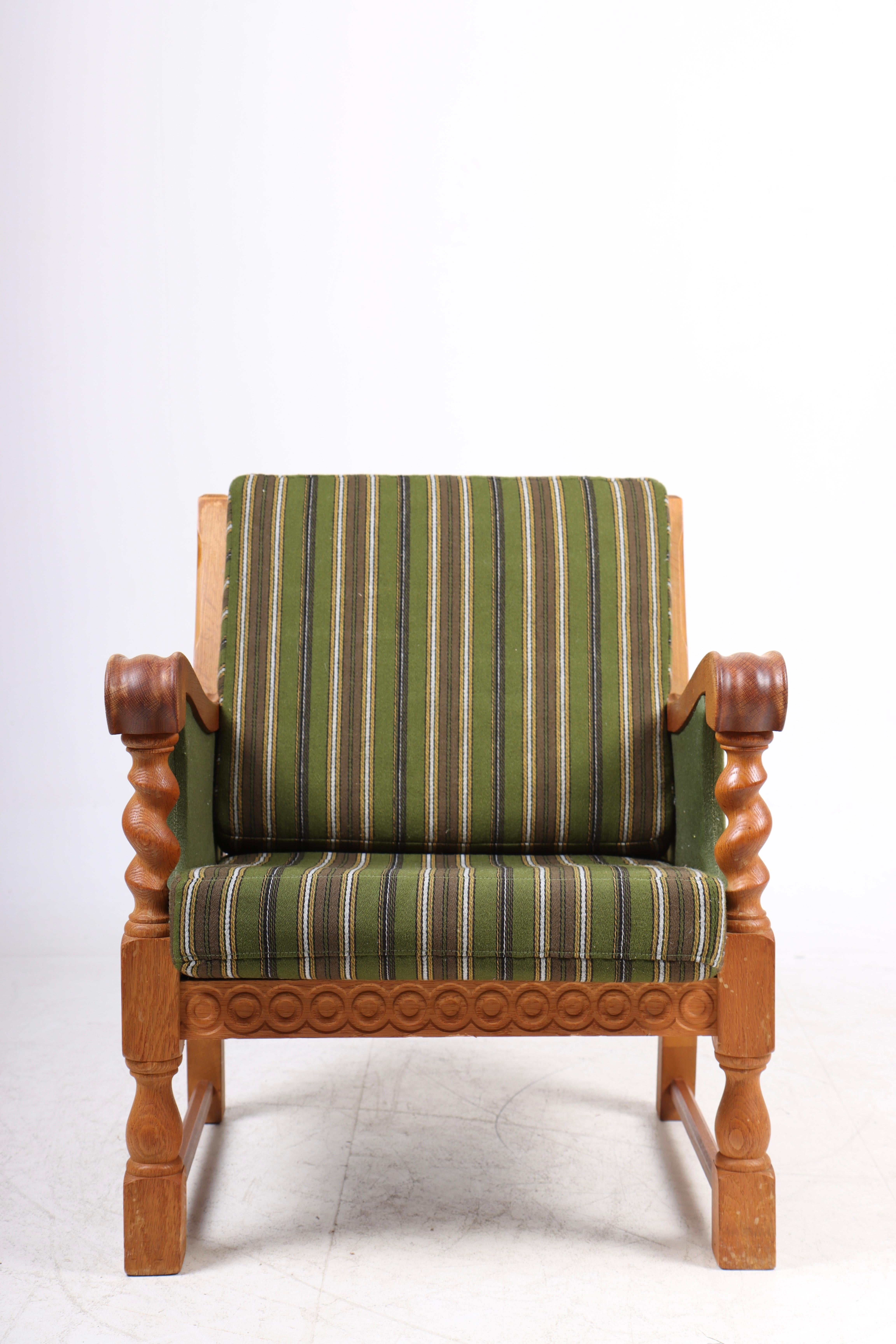 Lounge chair upholstered in fabric and solid oak. Designed and made in Denmark.