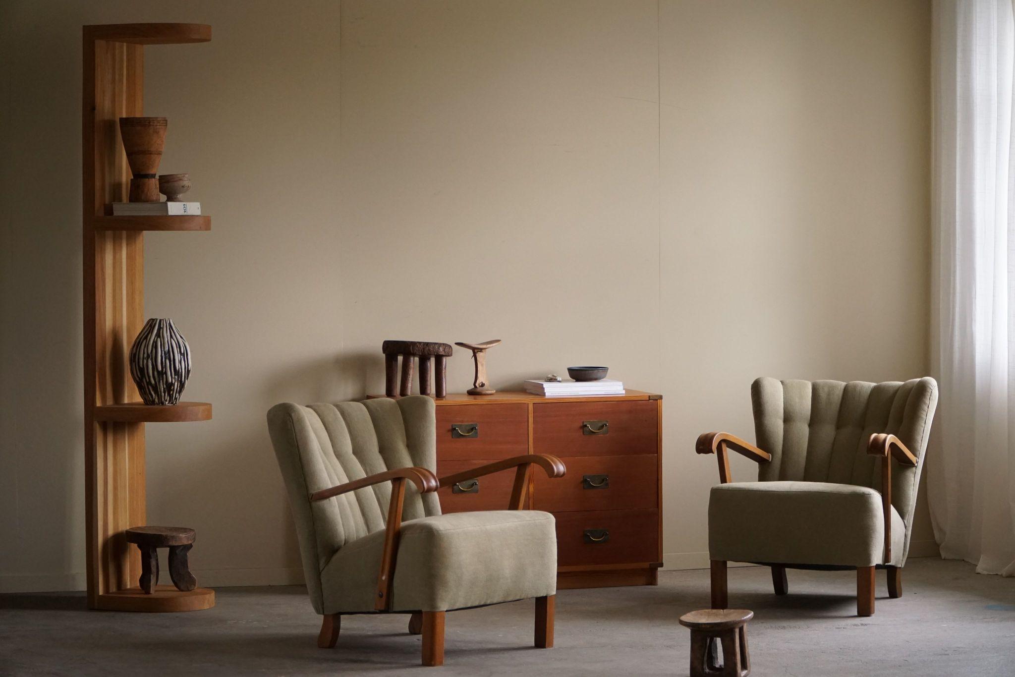 A timeless pair of comfortable Danish modern lounge chairs with armrests in solid oak and body reupholstered in a great quality olive green linen. Crafted by a Danish cabinetmaker in the 1960s.
These fine lounge chairs embodies the essence of Danish