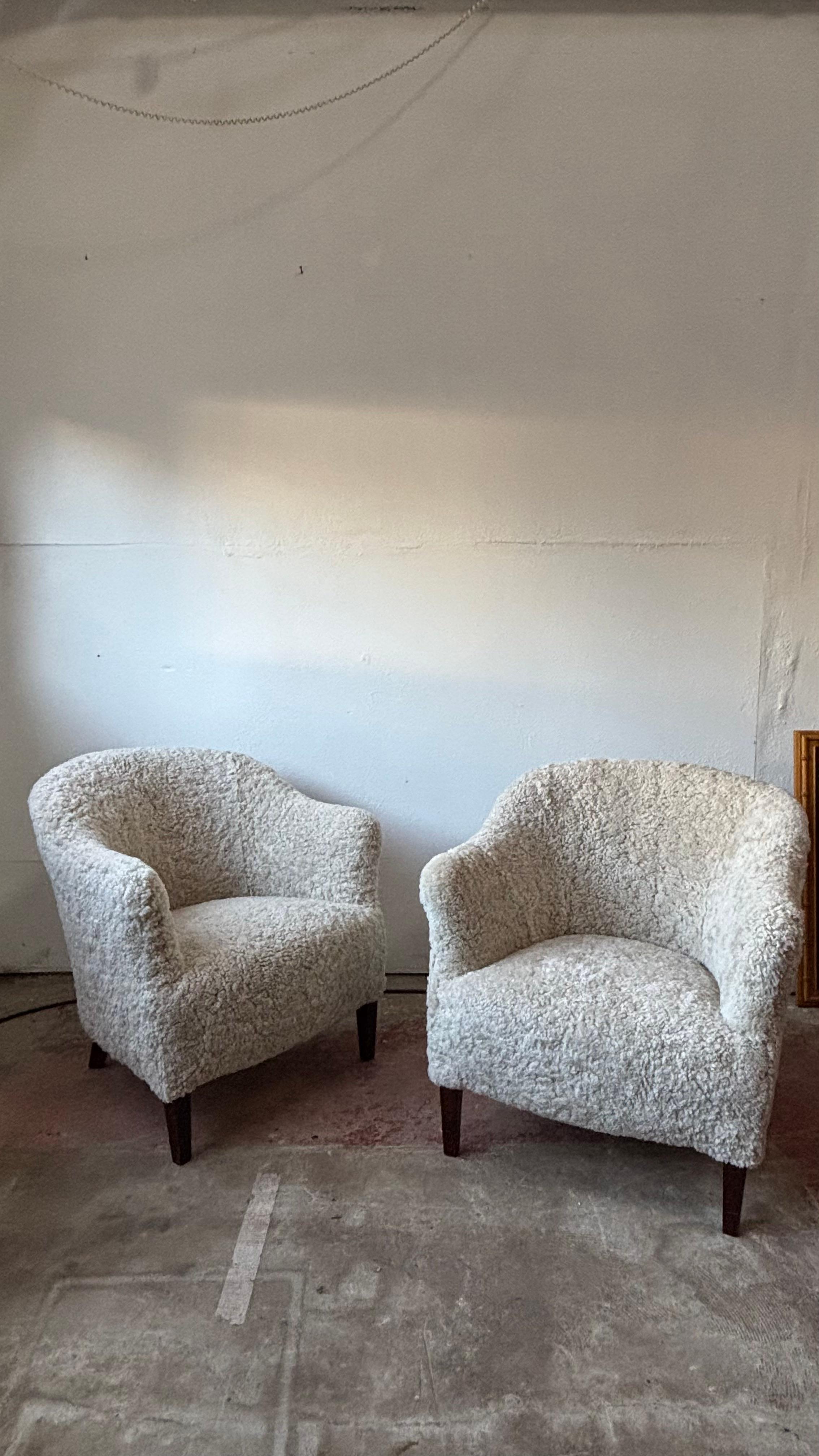 A beautiful pair of Mid-Century Modern lounge or club chairs made in Denmark in the 1950's.

This classic low profile, chic and comfy chairs sit in any interior with ease. We have had them newly upholstered in British Shearling, a luxurious natural