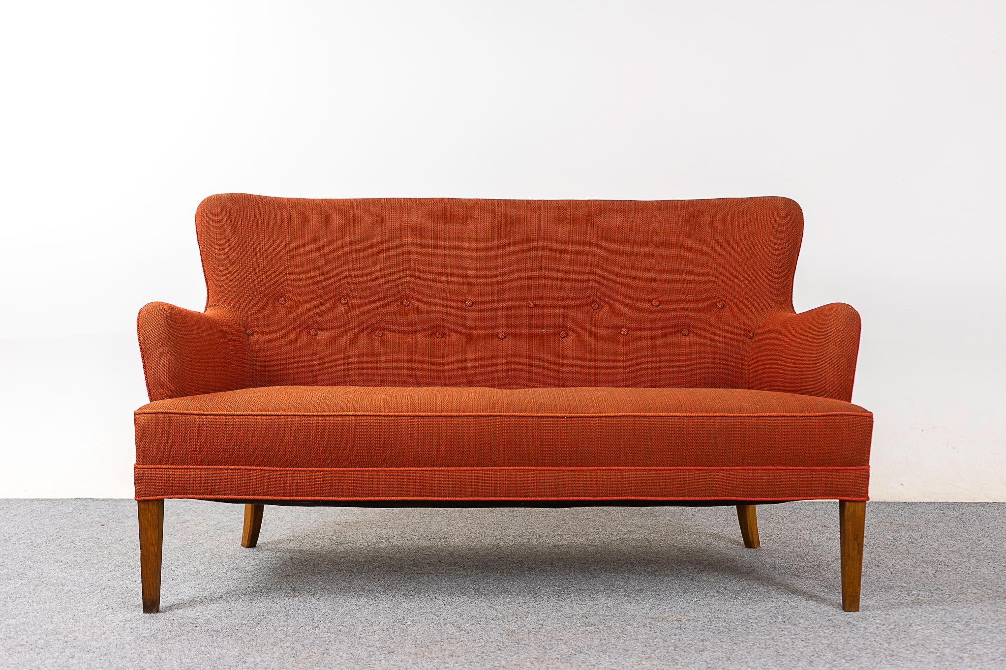 Causeuse moderne danoise, vers les années 1960. Charmante tapisserie d'origine orange brûlé avec dossier touffeté. Encombrement réduit, une solution d'assise parfaite pour les citadins dans des lofts ou des condos douillets. Pieds fuselés en bois