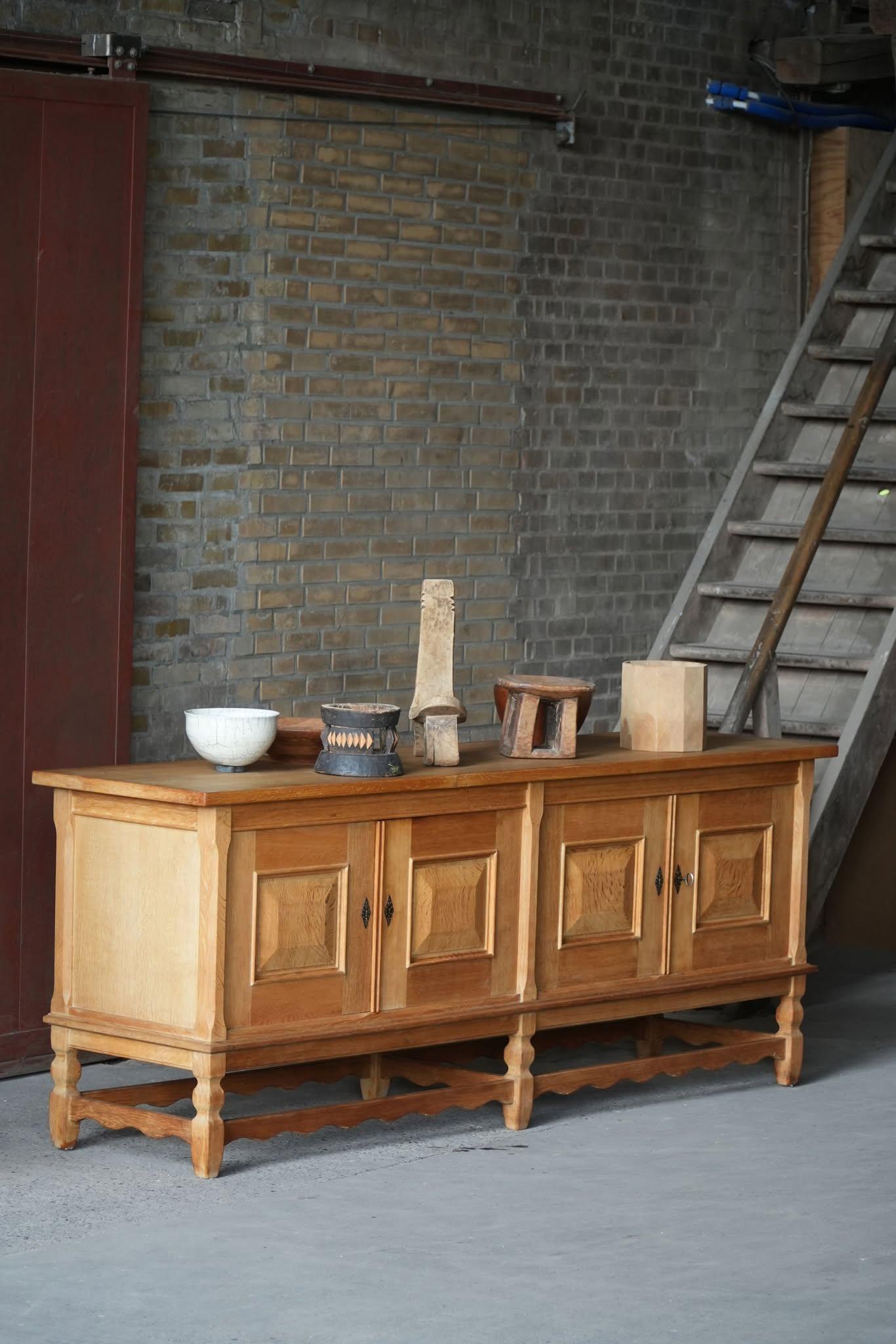 Buffet bas moderne en chêne. Magnifique design de la façade sculptée et riche espace de rangement. Conçu par Henning (Henry) Kjærnulf pour Nyrup Møbelfabrik dans les années 1960. Fabriqué en chêne, le buffet présente une présence robuste et