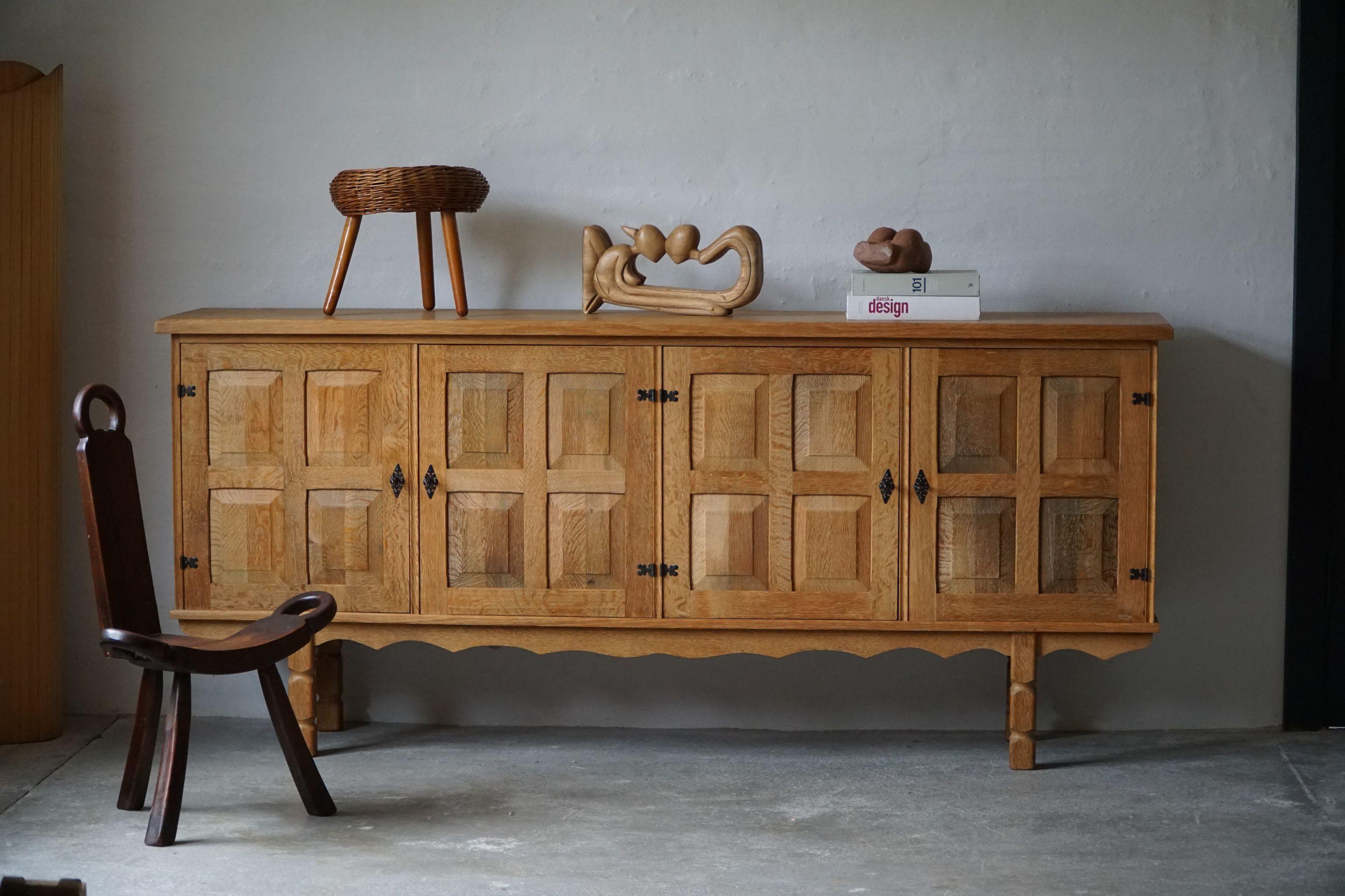 Danish mid century low rectangular sideboard, made in solid oak, ca 1950s

A great patina and a nice sculptural Front Design. 

With a heavy focus on functionality, this design style leans toward modernism, while incorporating coziness. The