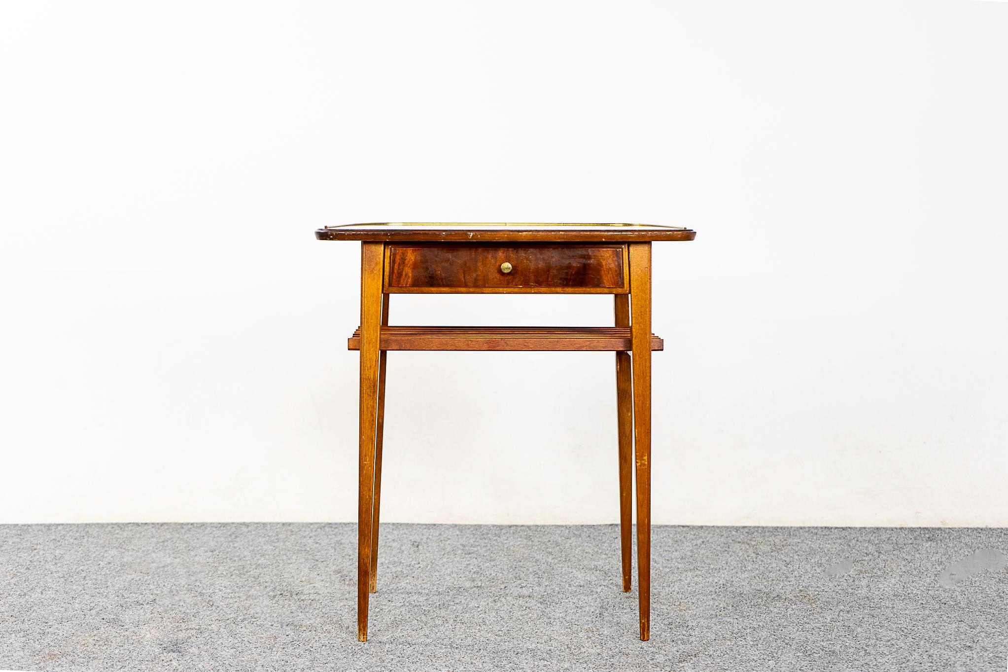 Mahogany Danish modern bedside table, circa 1960s. Beautifully veneered case rests on slender tapered legs. Drawer offer storage for small items while lower slatted shelf is perfect for your favorite book.

Unrestored item, some marks consistent