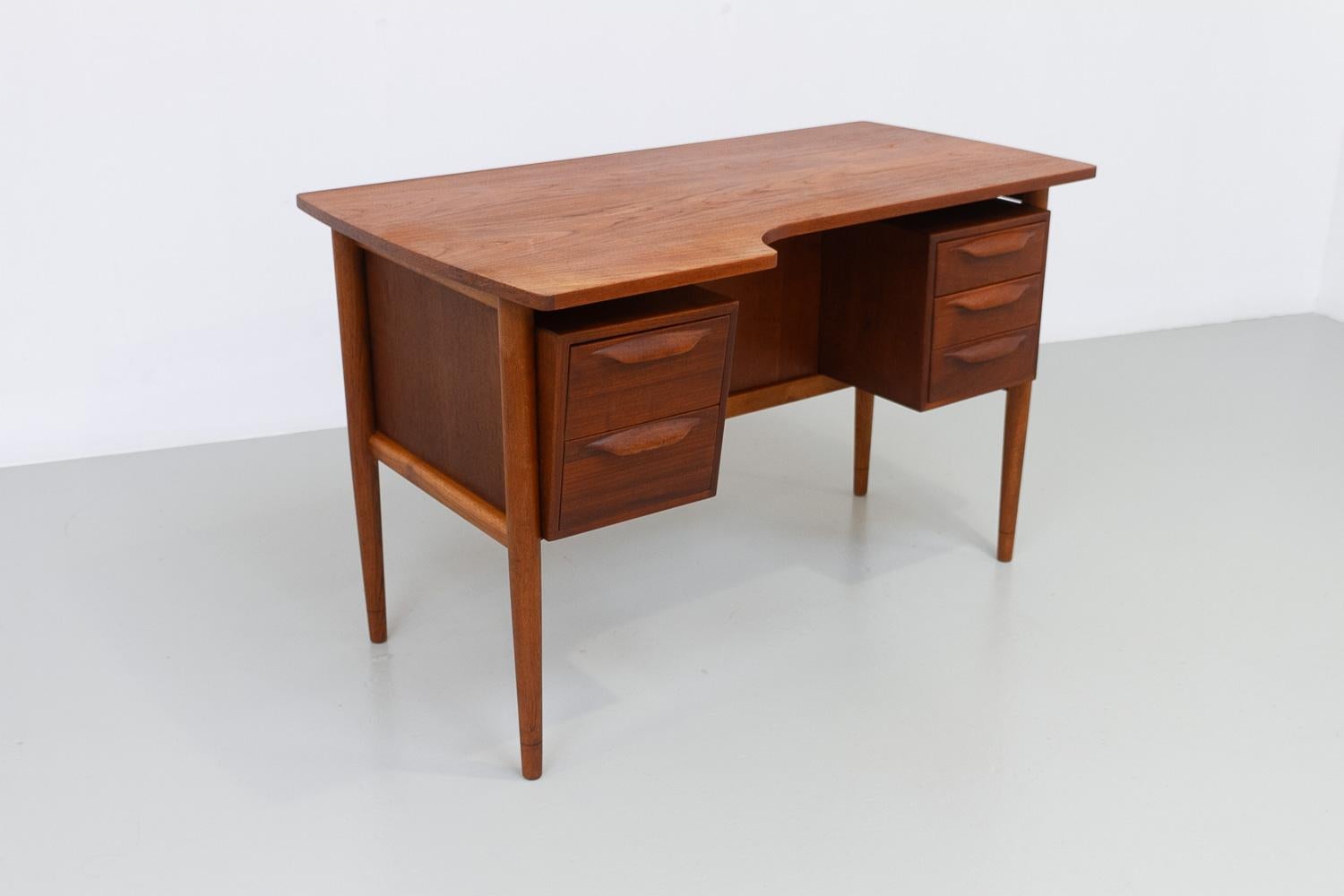 Danish Mid-Century Modern Asymmetrical Teak Desk, 1950s.

Rare and early freestanding Scandinavian Modern boomerang teak writing desk made in Denmark in the early 1950s. Asymmetrical table top and slanting drawer module front sets this desk apart