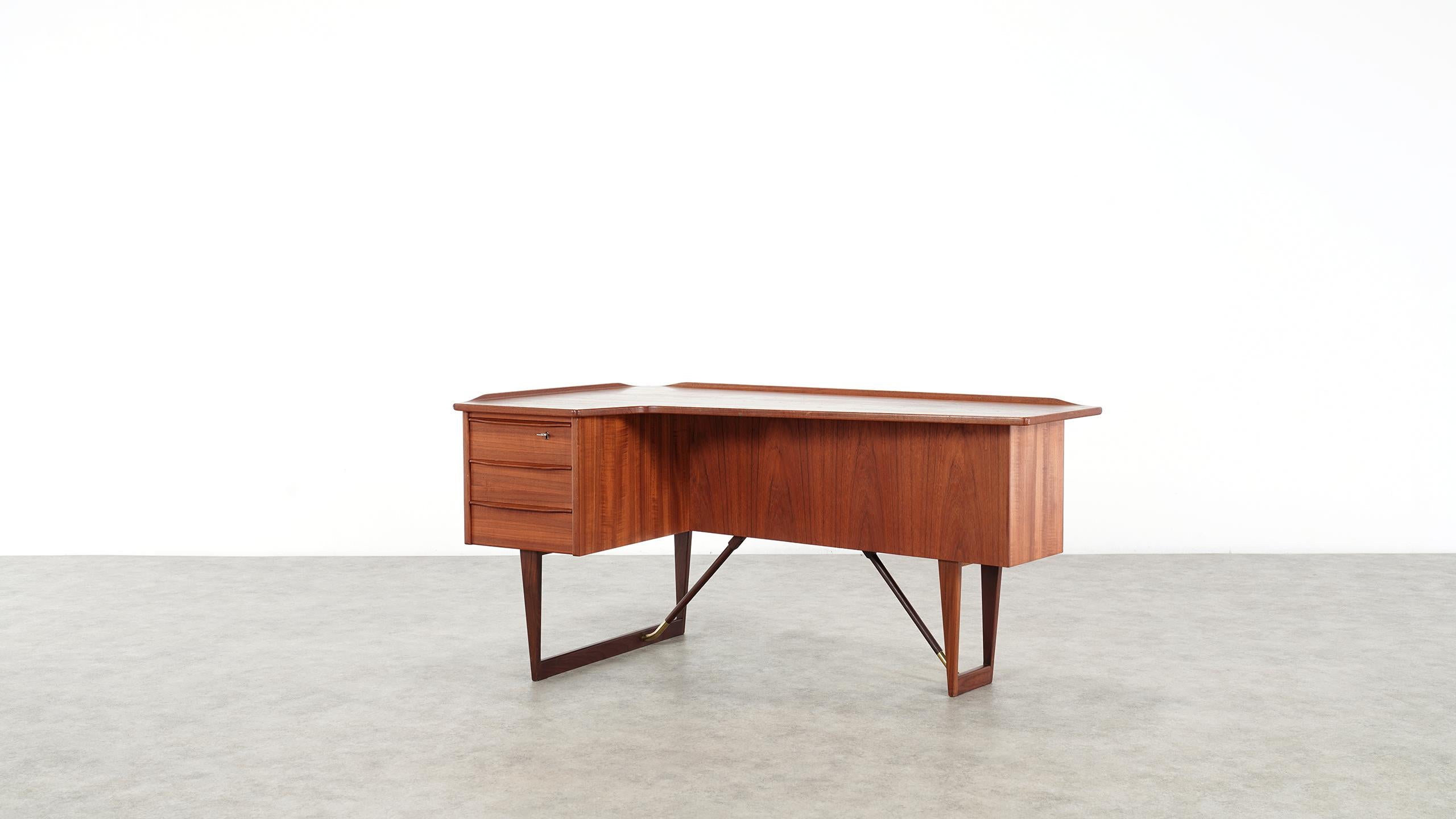 This free standing midcentury Danish writing desk was designed by Peter Løvig Nielsen for Løvig Dansk in 1969 (signed and stamped 1969, photo available). 

The front side features three drawers with an additional case in the top drawer. The