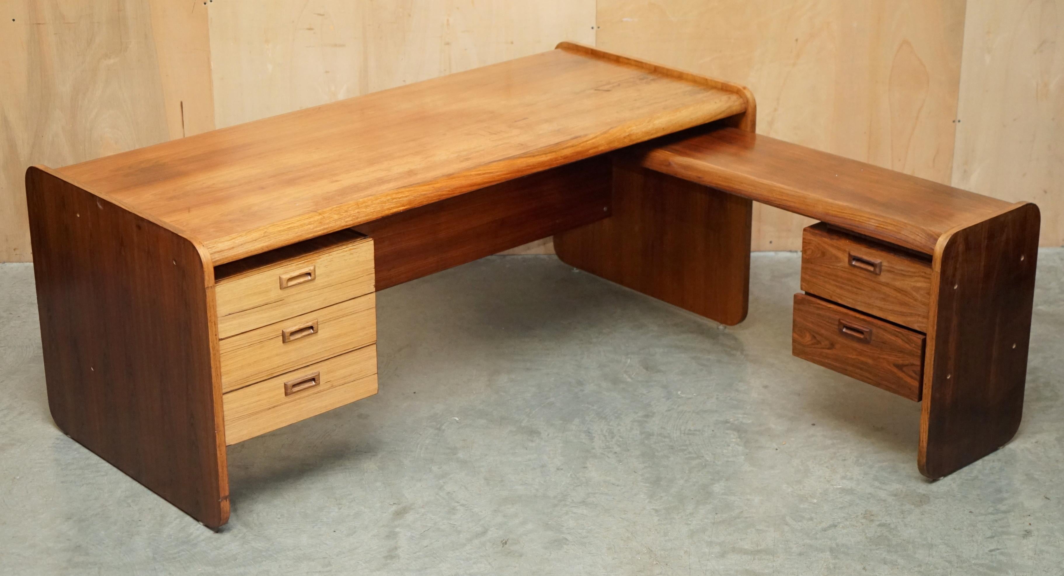 Royal House Antiques

The House Antiques a le plaisir de proposer à la vente ce très grand bureau d'angle droit en bois brésilien de style moderne du milieu du siècle, entièrement démontable pour faciliter le transport, qui fait partie d'une