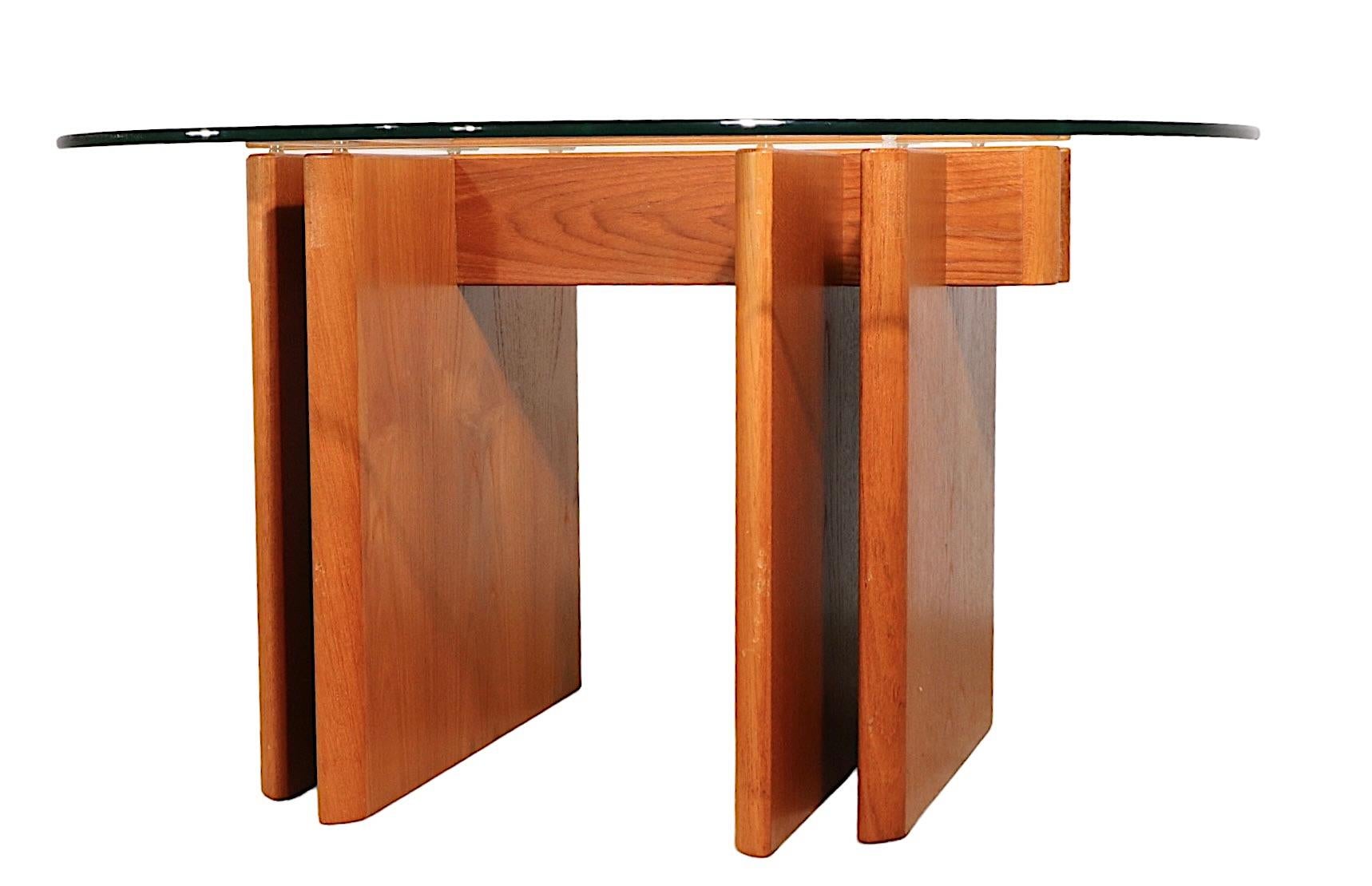 Stylish architectural mid-century Danish Modern coffee table designed by Gustav Gaarde, made in Denmark, by Trakanten circa 1960's. The table features its original thick plate glass top, ( .50 in. ) which is the less common circular shape, which
