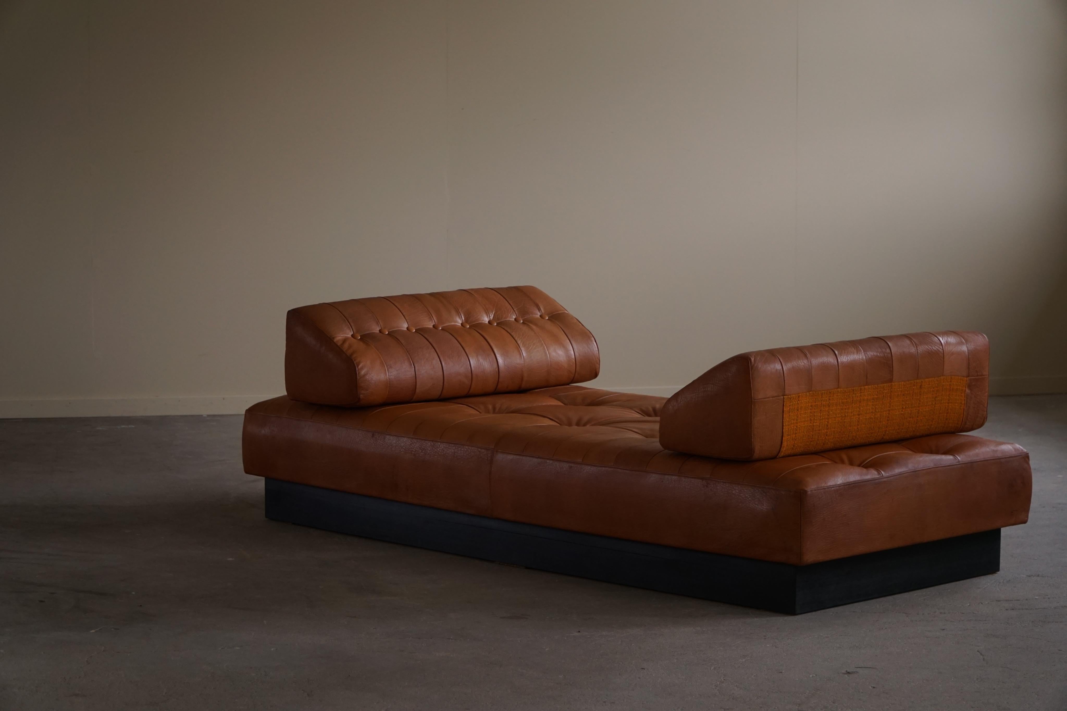 A beautiful freestanding daybed in cognac brown leather with storage space underneath. Two loose cushions that can be used as a back or neck rest. Made by a Danish cabinetmaker in 1970s. 

This daybed can also be used as a couch or a freestanding