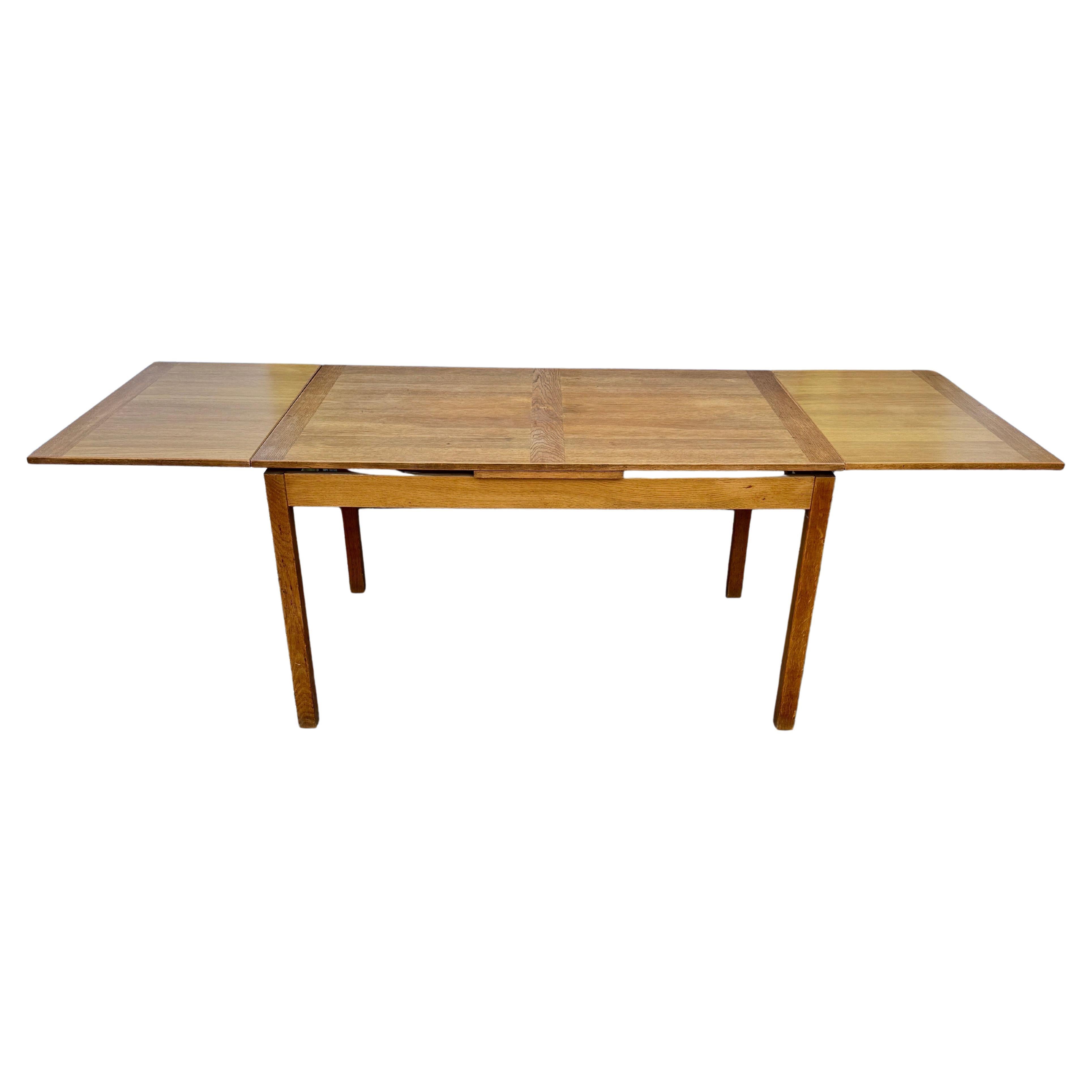Mid-Century Extension Dining Table, 1950's Denmark 

The natural aging and wood grain top is complemented by the solid wood frame. This expandable draw leaf table features classic Danish design with its clean lines. A perfect dining table for any