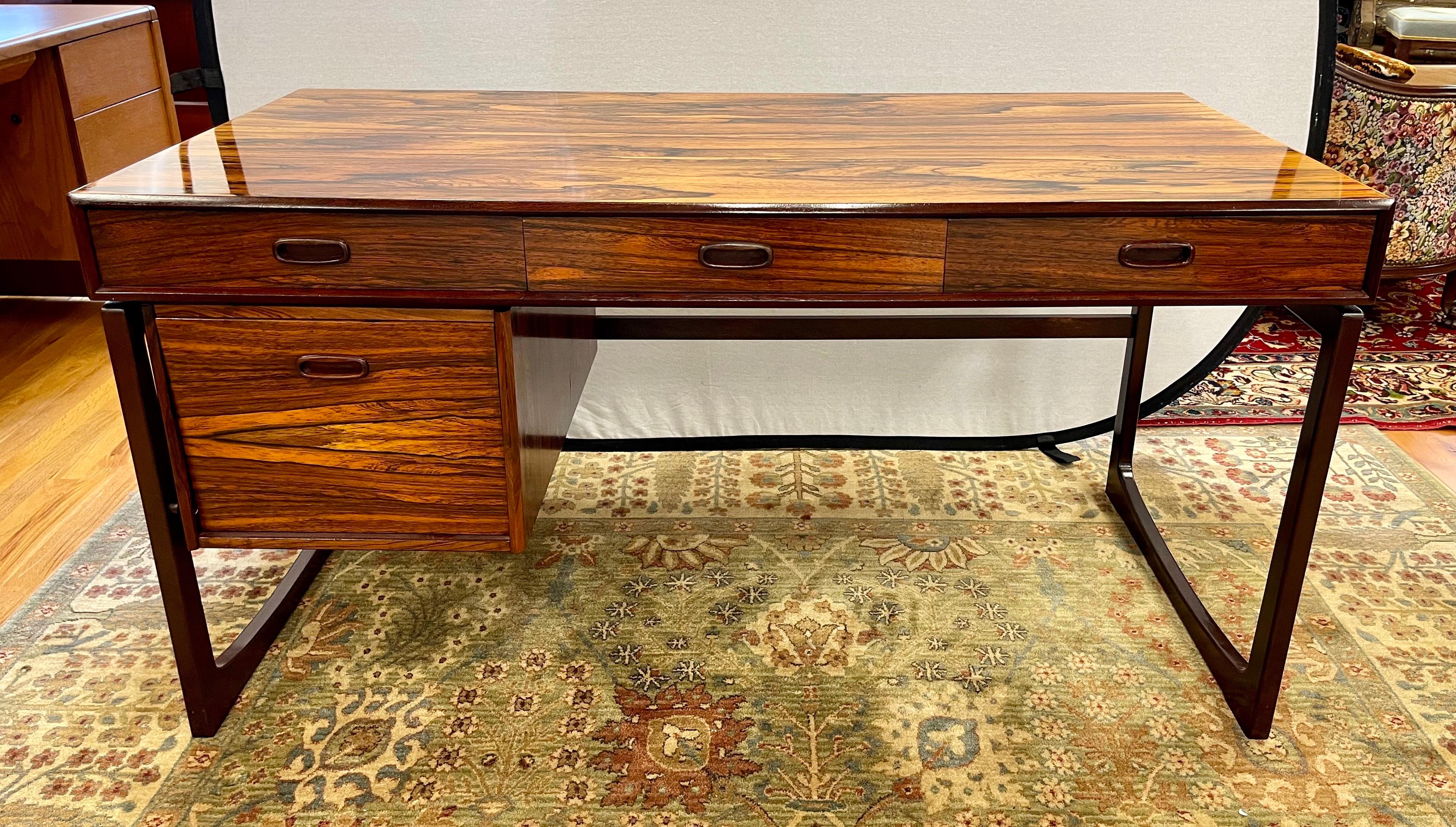 Stunning Danish Modern floating rosewood desk with three drawers at top and one bottom left drawer. The kneehole dimensions are 3 ft wide by 2 ft tall which gives plenty of room for any body type. The graining on the rosewood is sensational and has