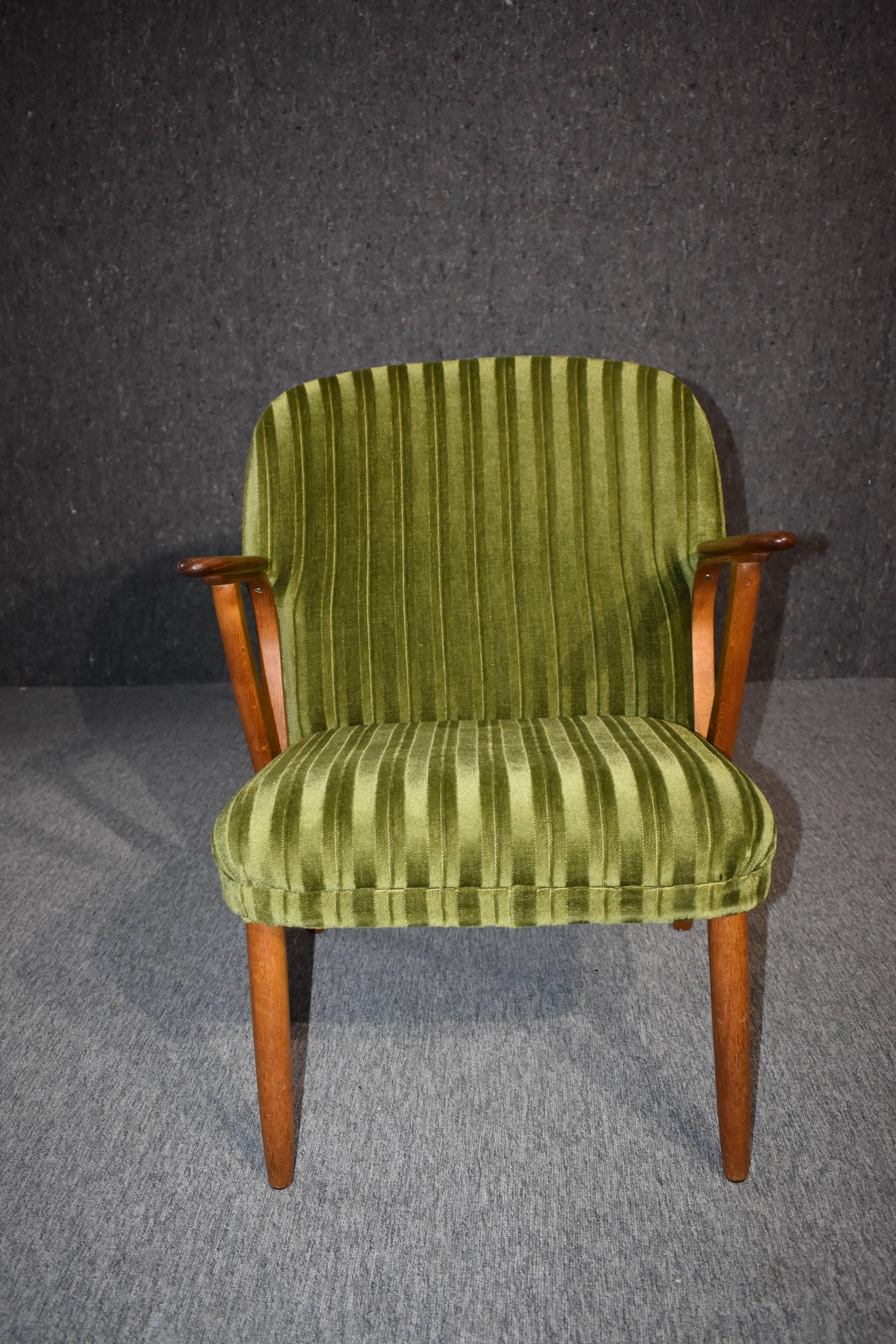 Very stylish midcentury lounge chair with green upholstery and armrest and frame in teak.
Produced in the 1960s.

 