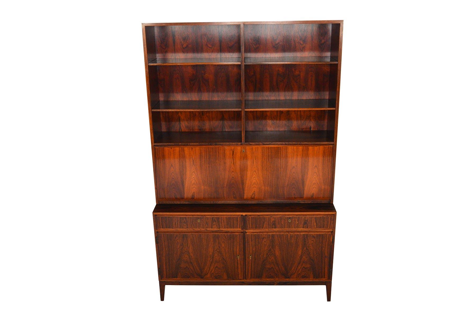 This versatile credenza with bookcase hutch was designed by Kai Winding in the 1960s. Flush cabinet drawers and doors showcase beautiful rosewood grain patterning. Lower cabinet offers two bays with adjustable shelving. The removable hutch top