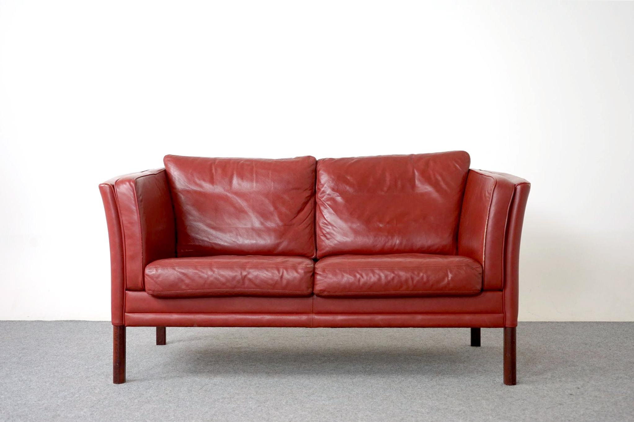 Leather Danish loveseat, circa 1960's. Leather is soft and supple, yet durable to ensure years enjoyment. Compact foot print make this the perfect seating solution for urban dwellers in cozy lofts or condos. Elegant curved sides and with beautifully