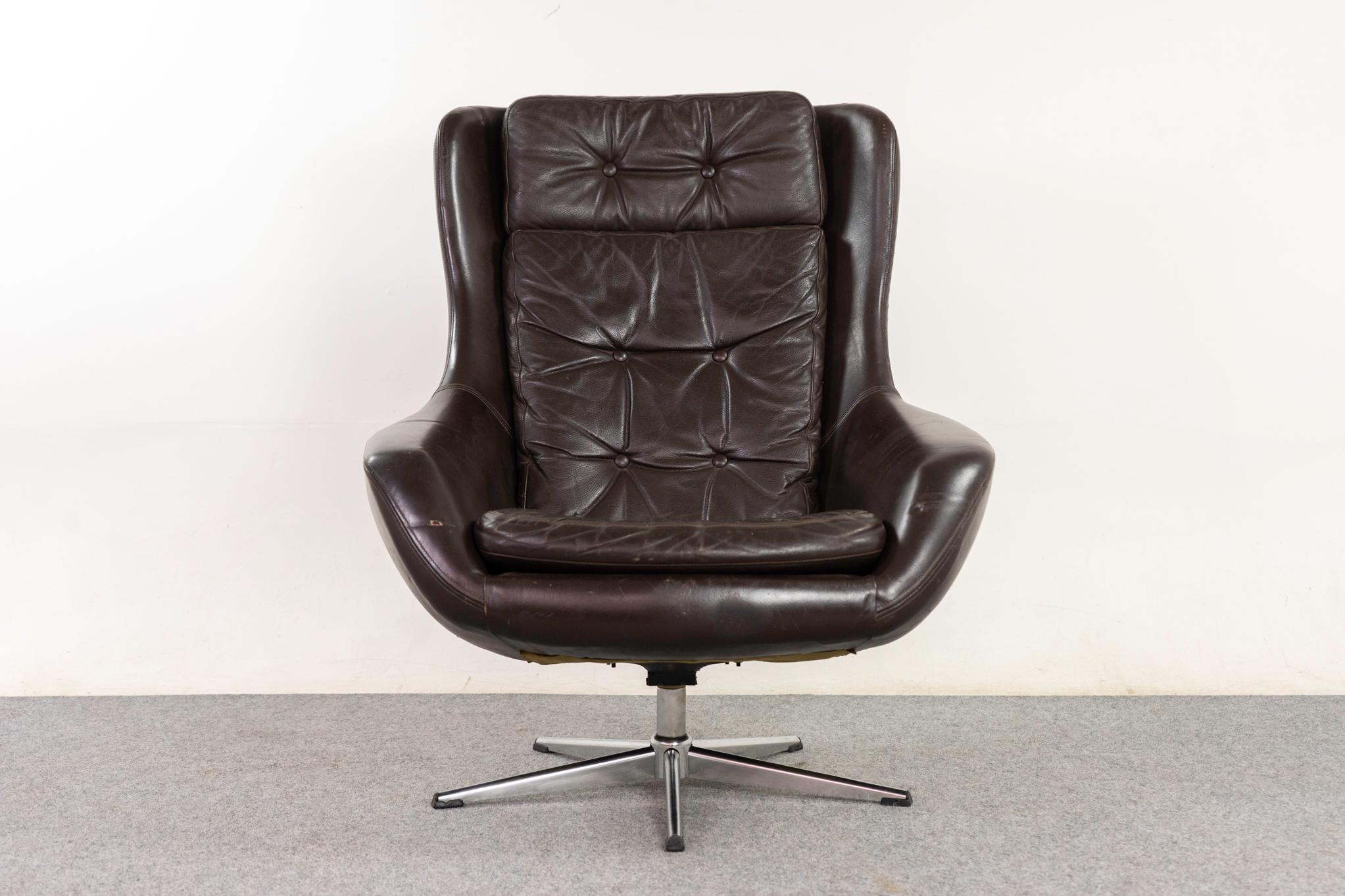Leather Danish swivel chair, circa 1970's. Extremely comfortable design with scooped silhouette and original tufted leather with minor wear.