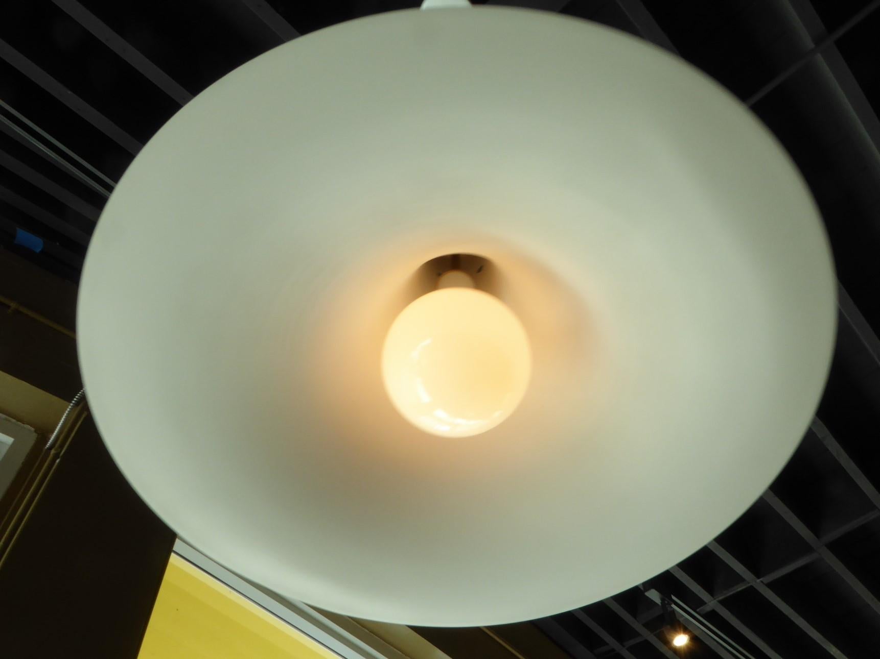 A Space Age Modern large 1970s pendant light by Bent Norsted for Lyskær Belysning  with a downward trumpet shape design in brushed aluminum with a white inside.  Takes a single bulb, medium base, often called Edison base (100 max. wattage).  We