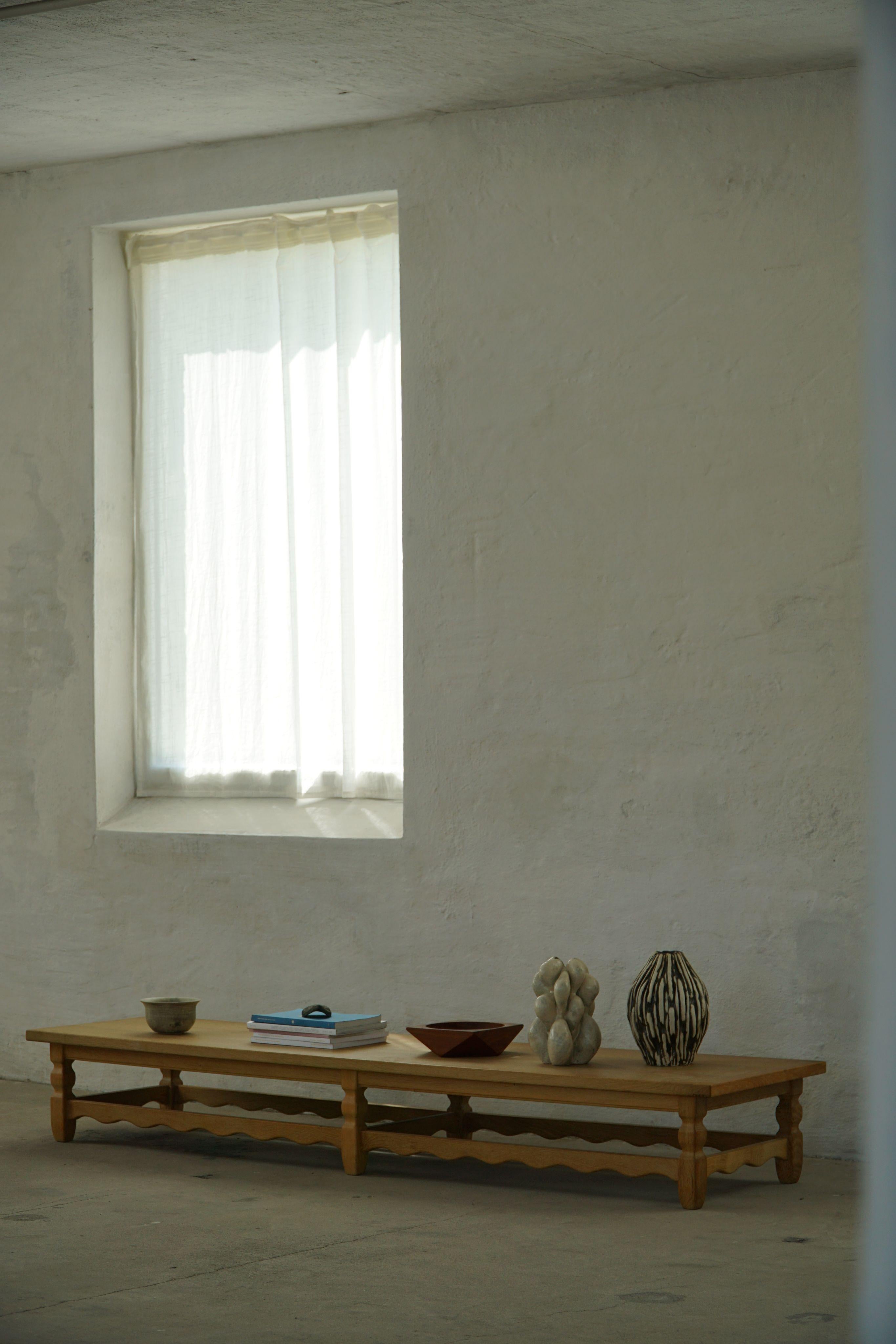 This rare and sculptural oak bench was designed by a Danish cabinetmaker in the 1950s. Attributed to Henning (Henry) Kjærnulf. Crafted entirely from solid oak, the piece is characterised by its oblong proportions and bold geometric carvings.
The oak
