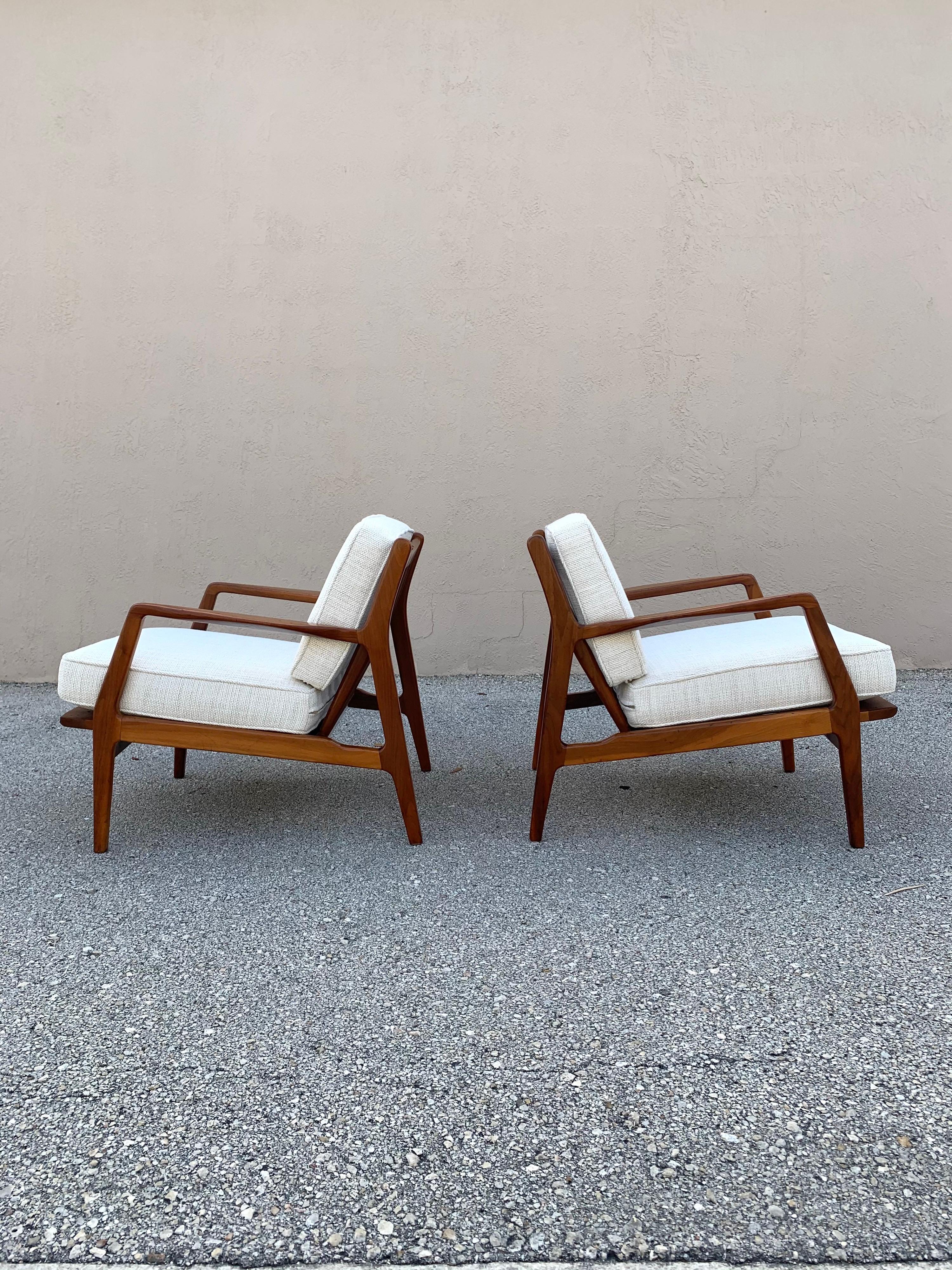 Pair of IB Kofod Larsen lounge chairs. Vintage from Denmark. Not tagged. Frames have been completely refinished in a process that still preserves some of the wear from their 60+ years of life. Some light scratching and marking. A new hand rubbed