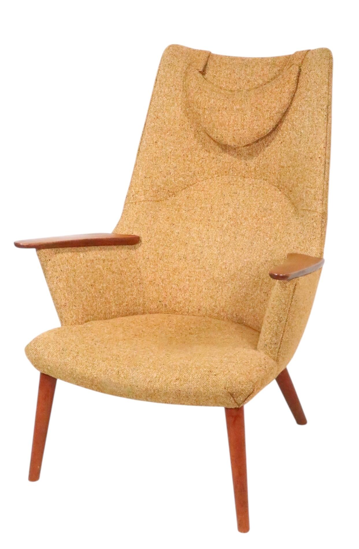 Modèle emblématique de la modernité danoise du milieu du siècle, AP-27, conçu par Hans Wegner, fabriqué par AP-Stolen, connu sous le nom de chaise Mama Bear. La chaise présente un dossier exagérément haut, des accoudoirs en teck écorché et des pieds