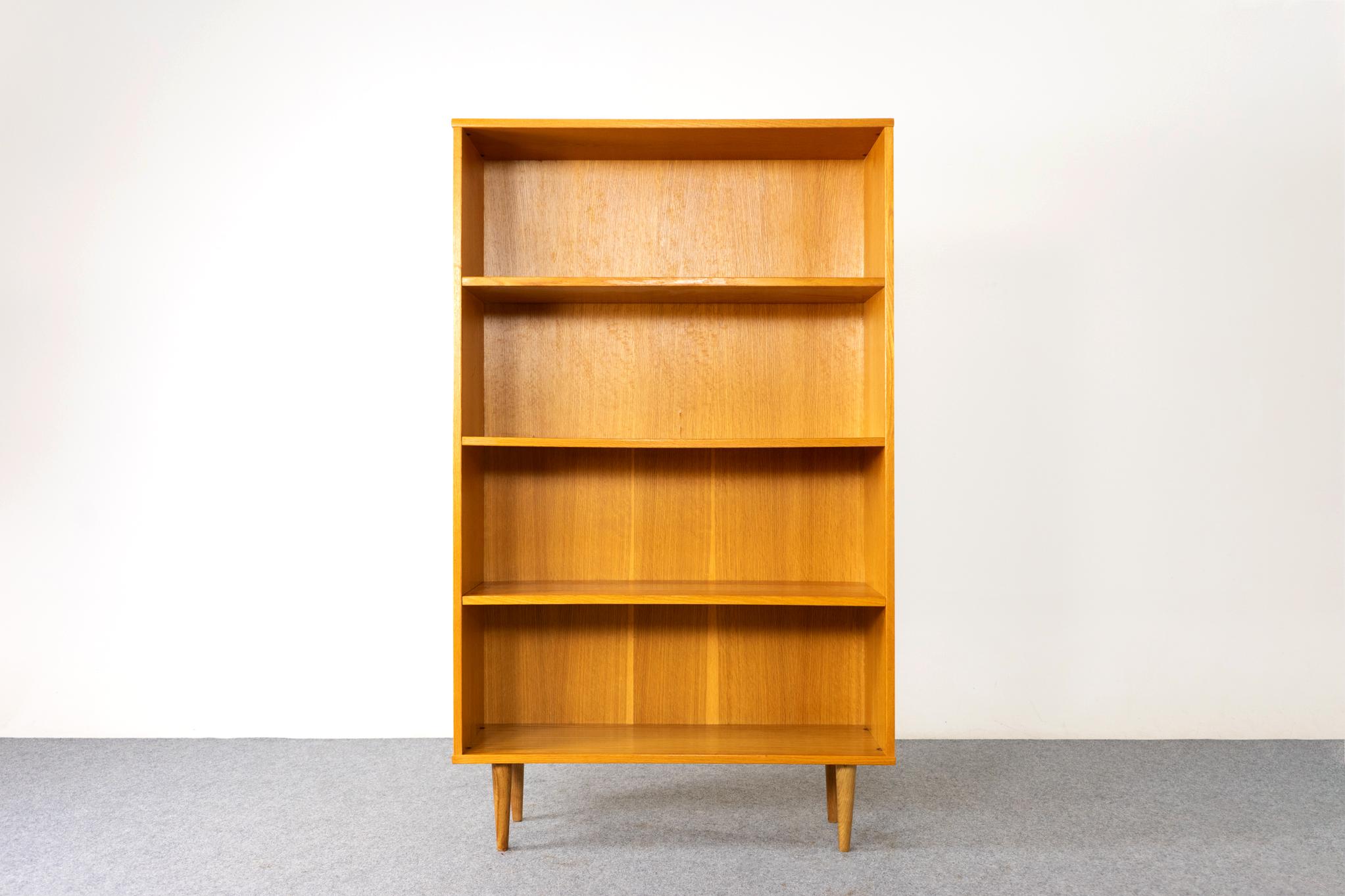 Oak Danish bookcase, circa 1960's. Open bookcase with adjustable shelving and lovely gain. Removable legs and compact design makes it the perfect condo sized storage solution. 

Unrestored item, some marks consistent with age.

Please inquire for