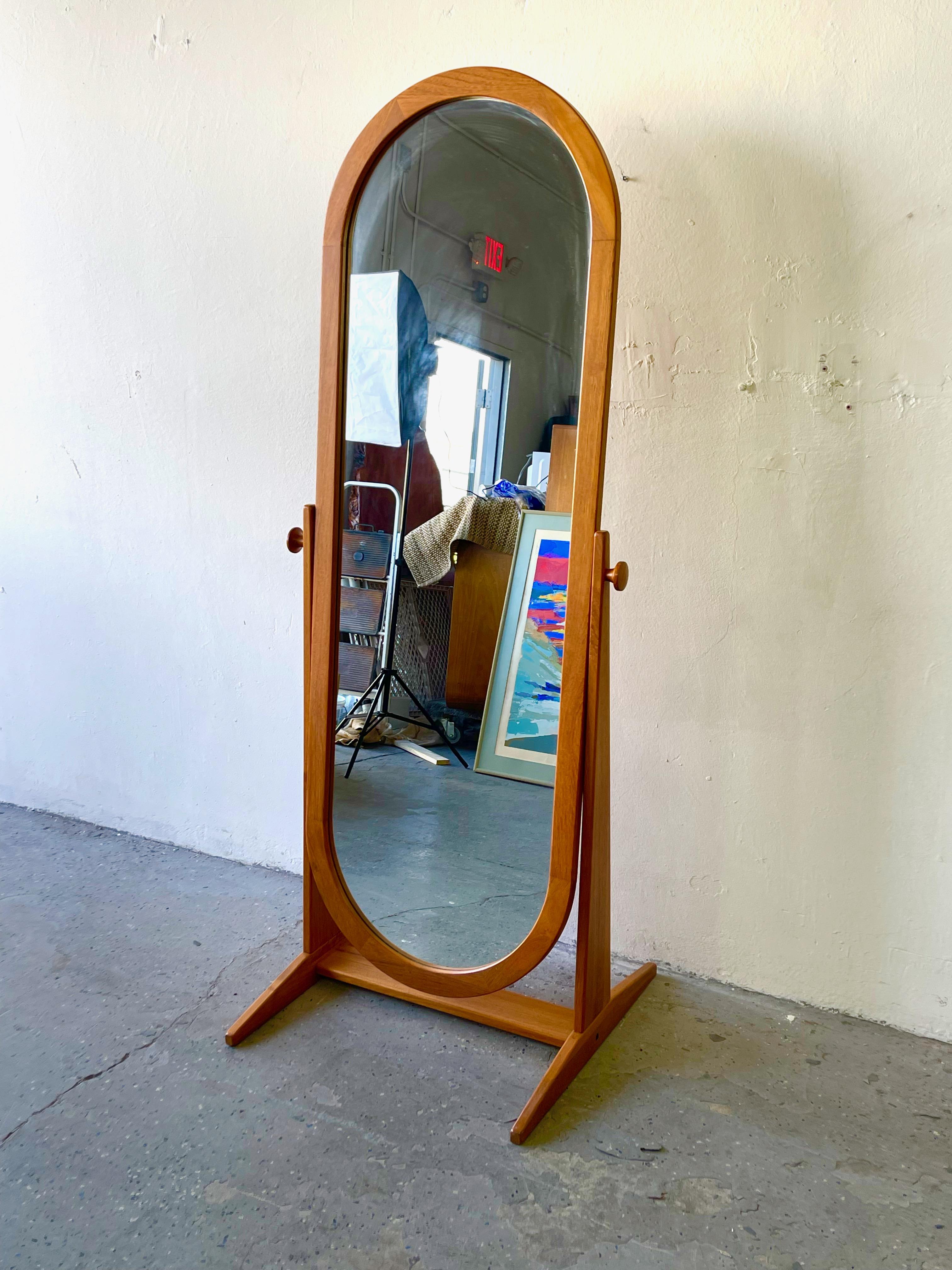 This full length floor mirror by Pedersen & Hansen Viby J Made in Denmark has an elongated oval shape that contrasts nicely with the angular frame. The mirror pivots to adjust the position, and it's held in place with turned teak knobs.

