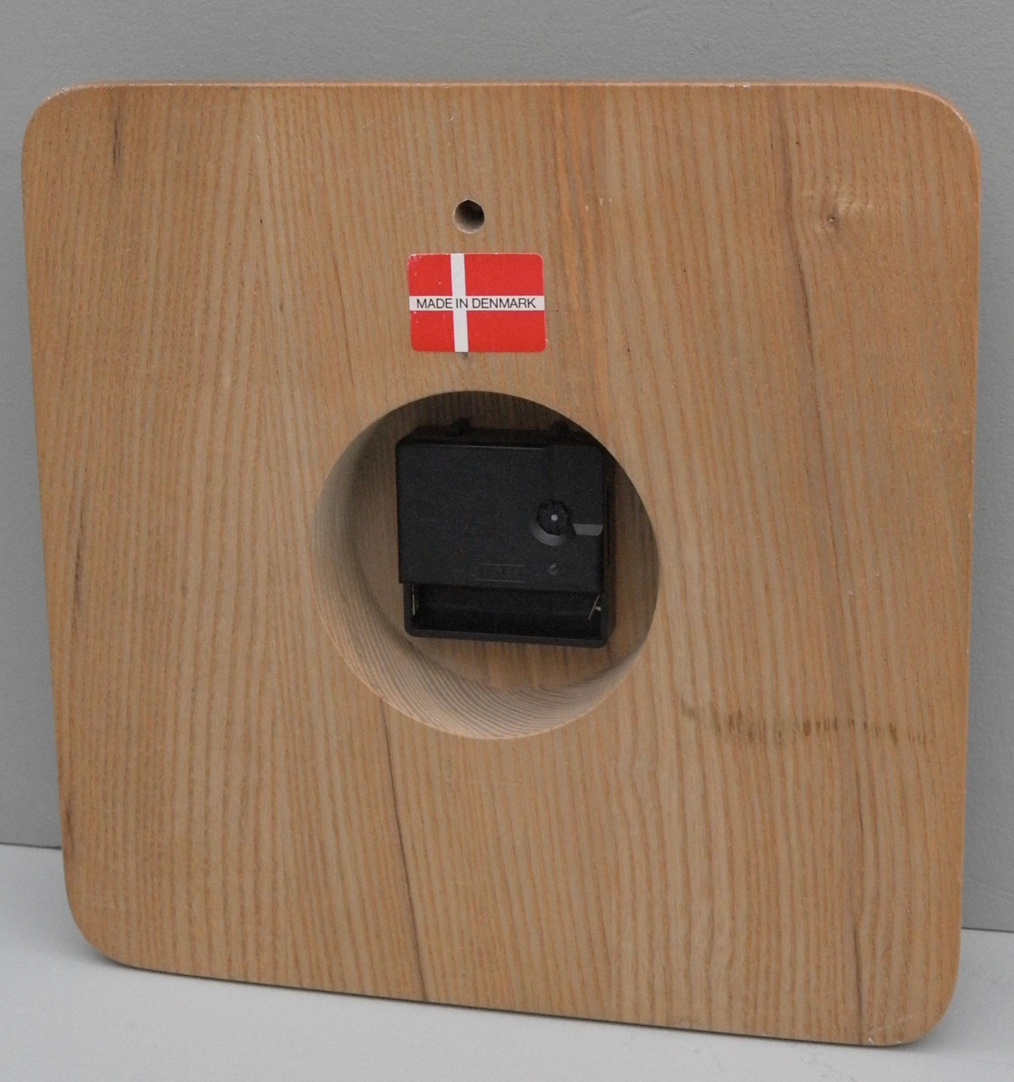 Danish Mid-Century Modern pine and brass wall clock. Original new old stock item.