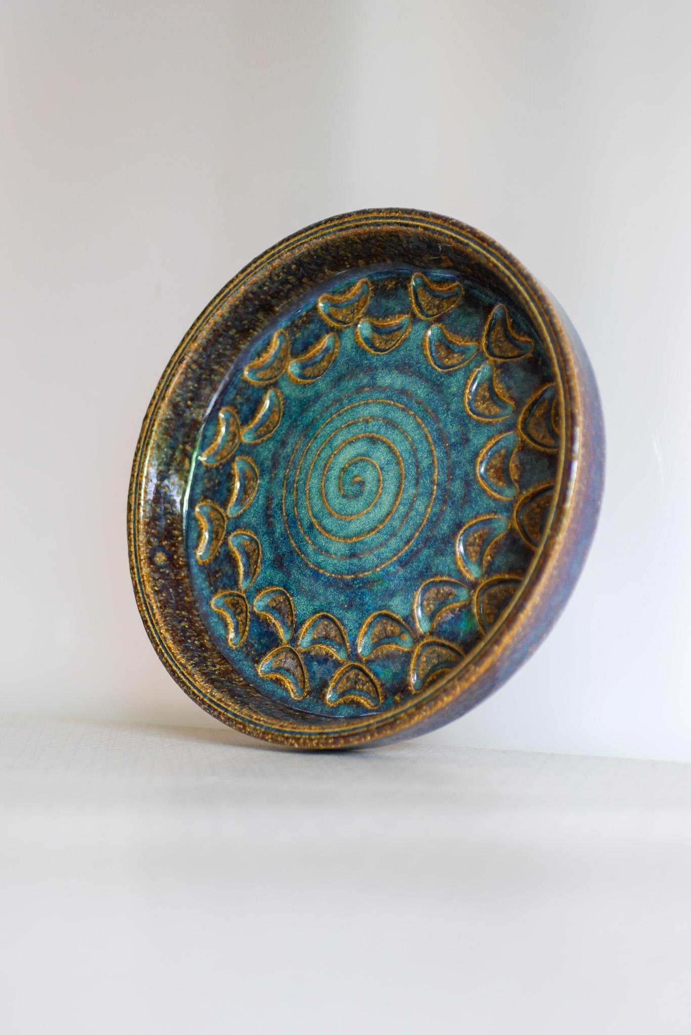 A small stoneware vintage Bornholm pottery plate or Vide-poche from Denmark. Made by the talented Michael Andersen, this plate is iconic and so typical for this company, especially when it comes to the glazing. The colors are a very nice various