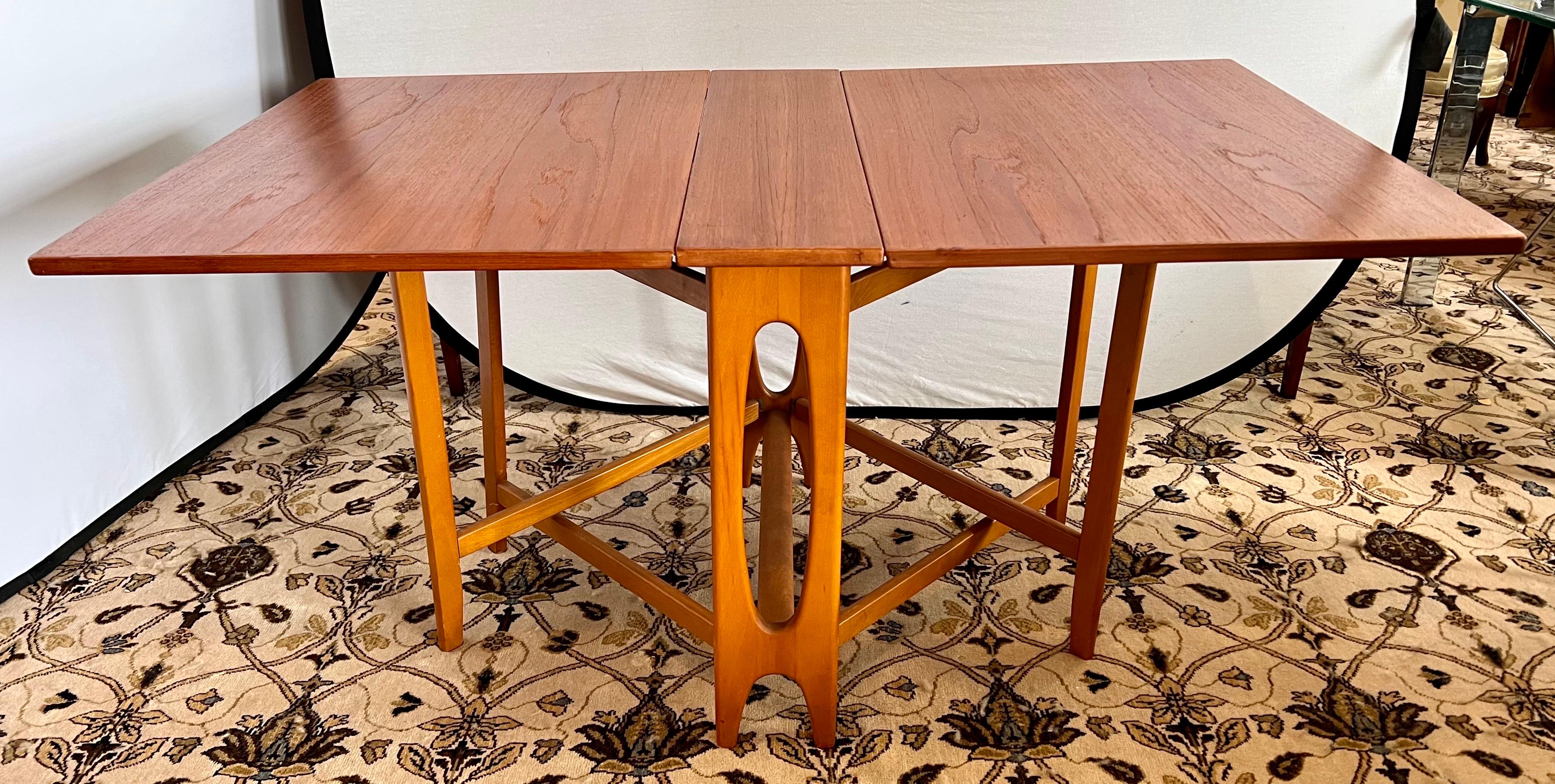 Rare Danish Modern teak dual gate leg dining table. Dimensions are below when table is open. When closed, it measures 8.5