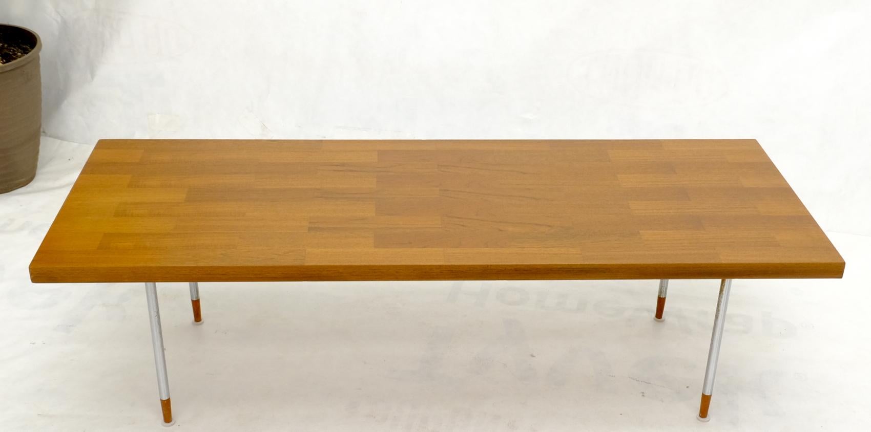 Table basse rectangulaire en teck, de style moderne du milieu du siècle, reposant sur des pieds cylindriques chromés avec des extrémités de pieds coniques en teck massif. Fabriqué en Hollande.