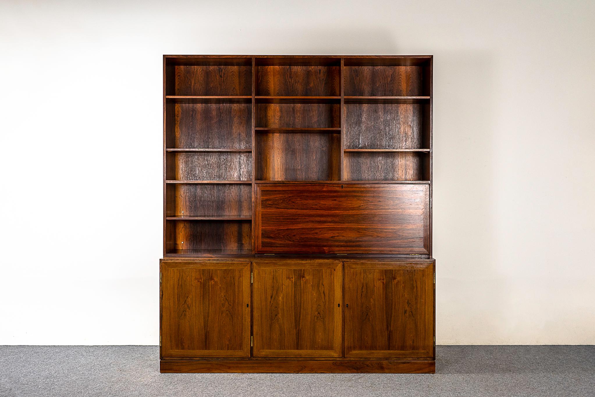 Rosewood Danish bookcase cabinet by Kai Winding, circa 1960's. Highly functional design combines open shelving, lower cabinetry and a drop down desk with fitted interior.

Please inquire for international and remote shipping rates.
