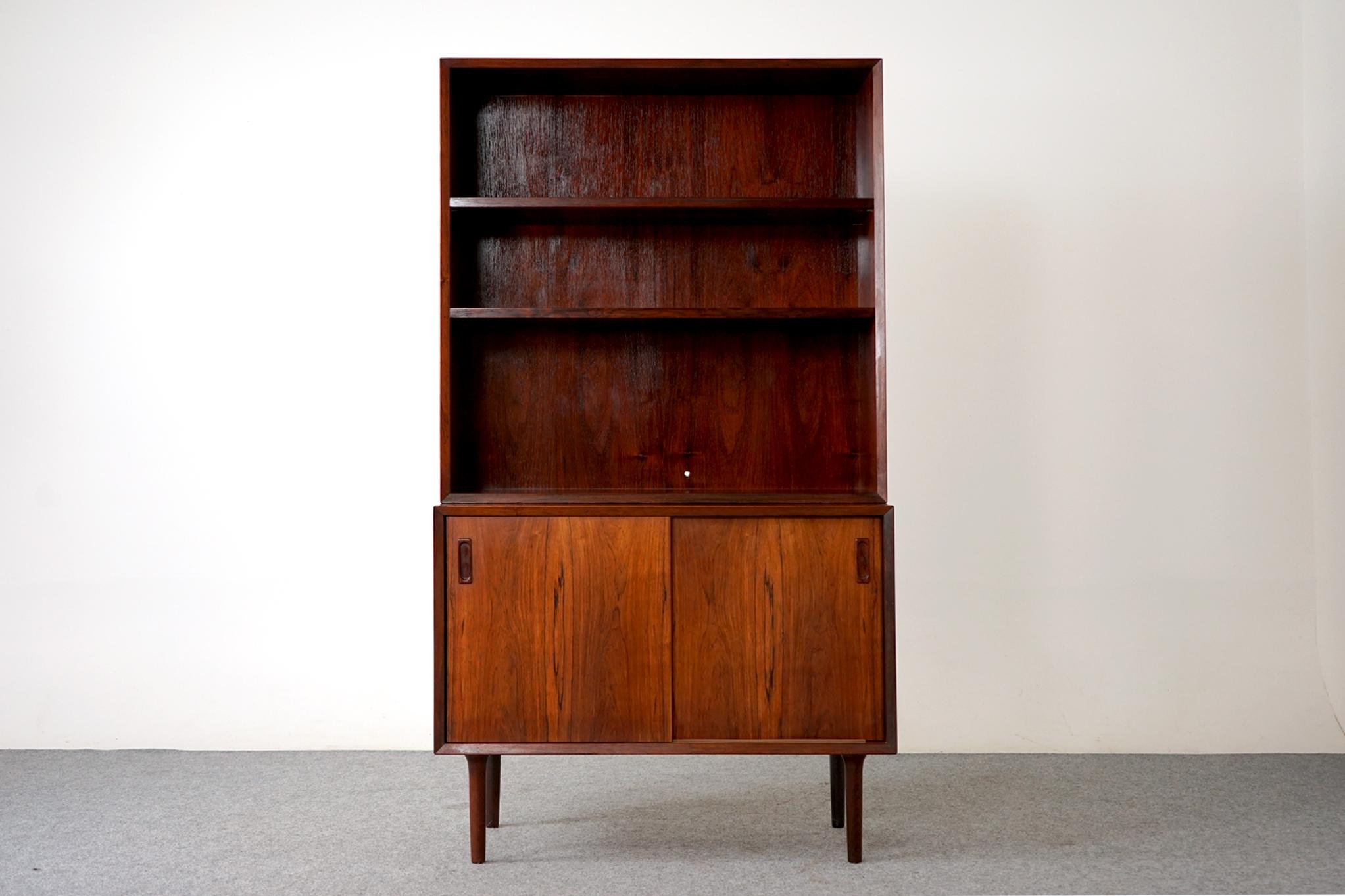 Rosewood Scandinavian bookcase/cabinet by Lyby Mobler, circa 1960's. Open bookcase rests upon a sliding door cabinet, could be used seperately. Case sits upon removable, tapered solid wood legs, adjustable shelving to suit your needs! Stamped