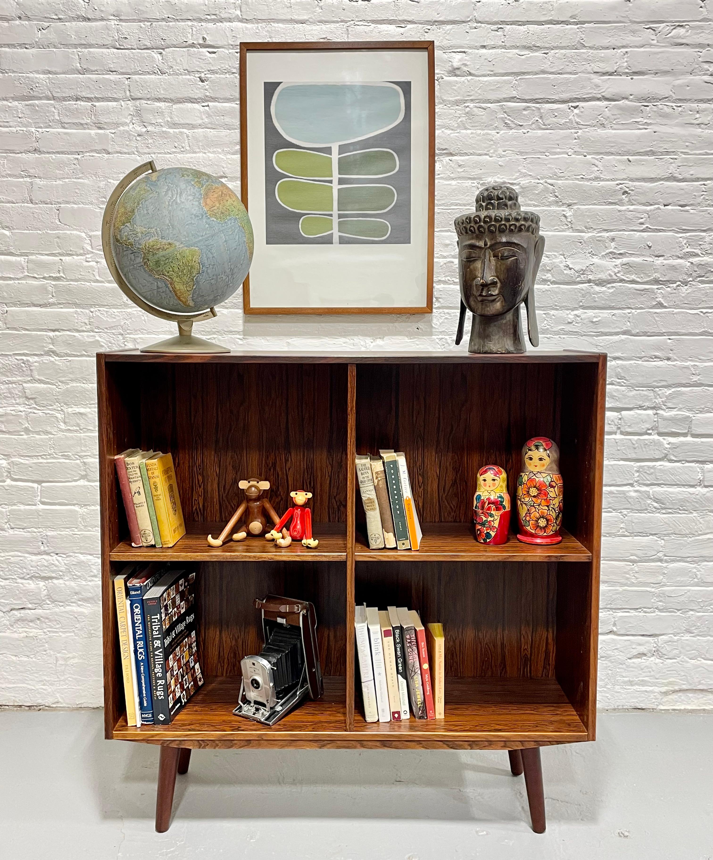 Danish Mid Century Modern Rosewood Bookcase / Vinyl Storage, c. 1960’s.  Loads of storage for all your books and collectables or vinyl collection across the four adjustable shelving areas.   Constructed in rosewood and its deep, rich color and