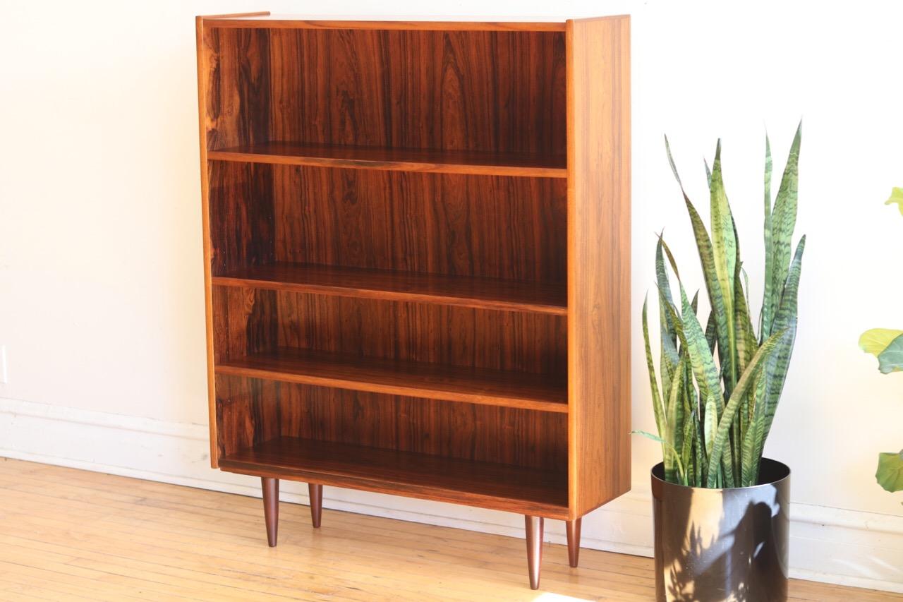 Mid-Century Modern Danish rosewood shelving unit.
Just imported from Copenhagen!
Adjustable shelf heights. 
Beautiful rosewood woodgrain.
Excellent vintage condition!

Measures: 39 3/8” wide x 11 1/8” depth x 50 7/8” tall.
 