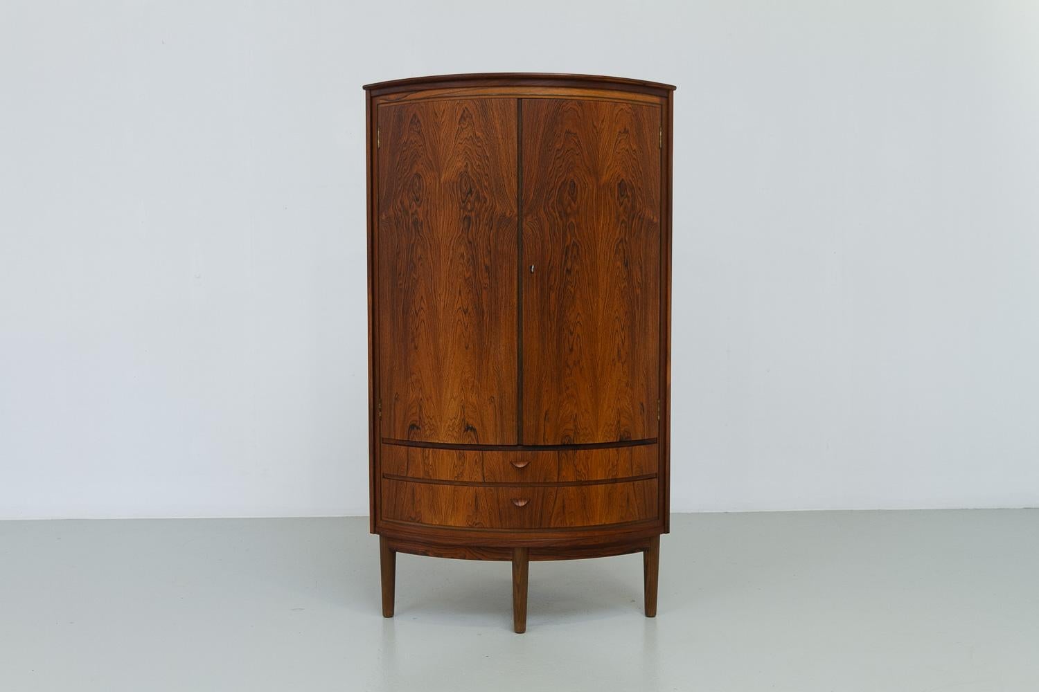Meuble d'angle en palissandre danois de la Modernité du milieu du siècle, années 1950. 

Magnifique meuble d'angle en bois de rose avec façade arrondie. Grand compartiment avec trois étagères triangulaires en acajou. L'intérieur est également très