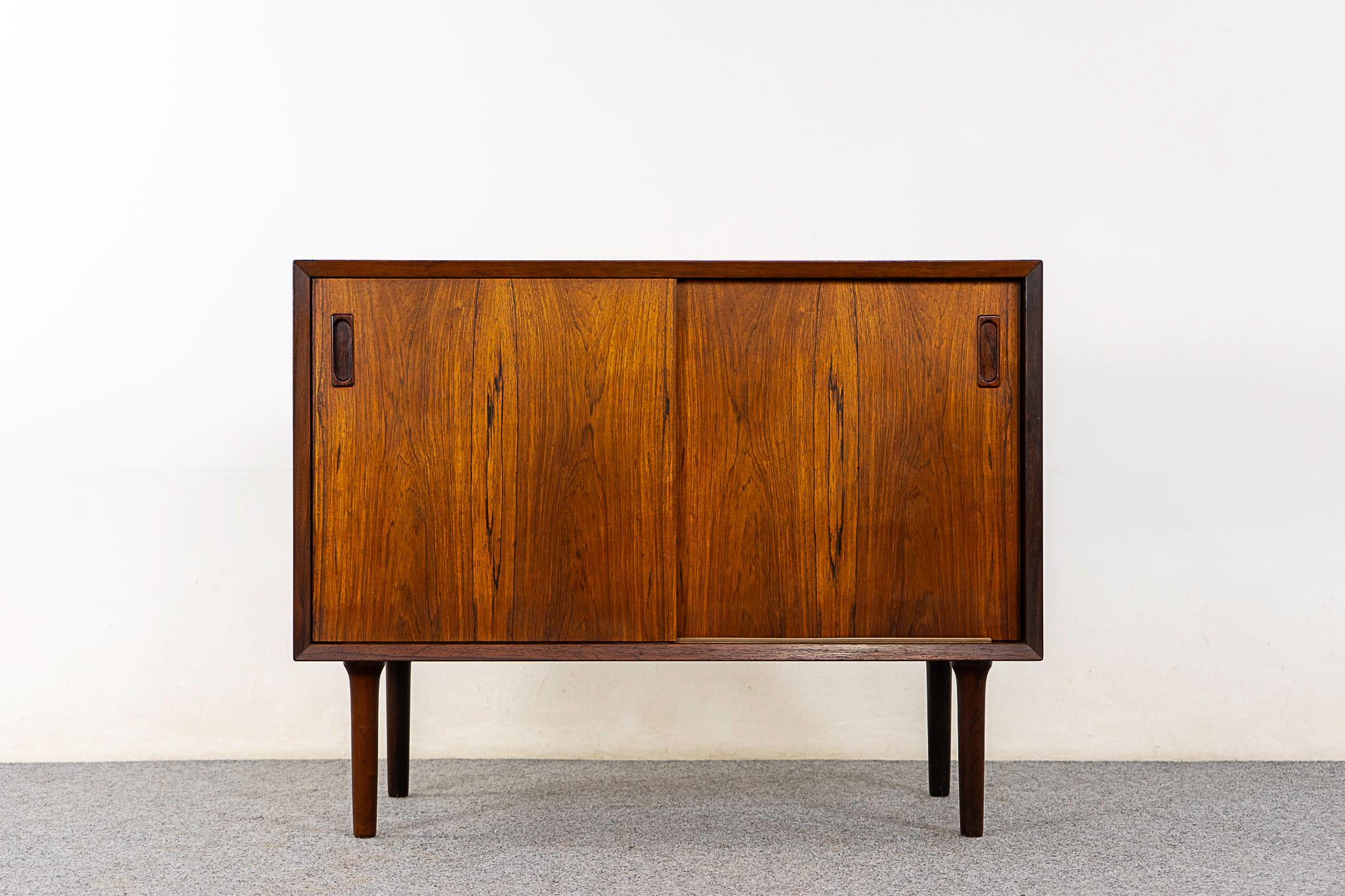 Rosewood cabinet by LYBY Mobelfabrik, circa 1960's. Beautiful book-matched veneer with lovely grain patterns and sleek finger pulls. Robust sculpted legs and beveled edge solid wood trim. Adjustable interior shelf with 5 height options. A perfect