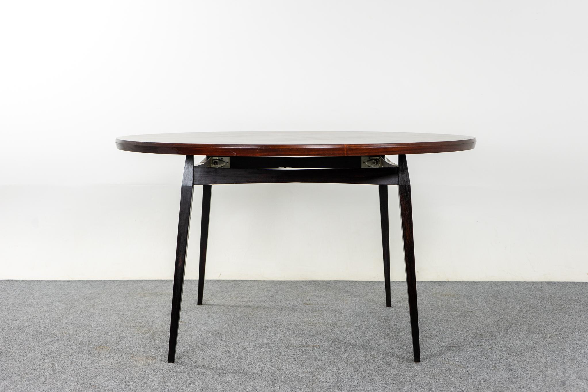 Rosewood Danish dining table, circa 1960's. Table top boasts highly figured grain patterns in the veneer. The floating top rests on a unique contrasting angular base, very complimentary! Round tables create space and more intimate dinner settings,