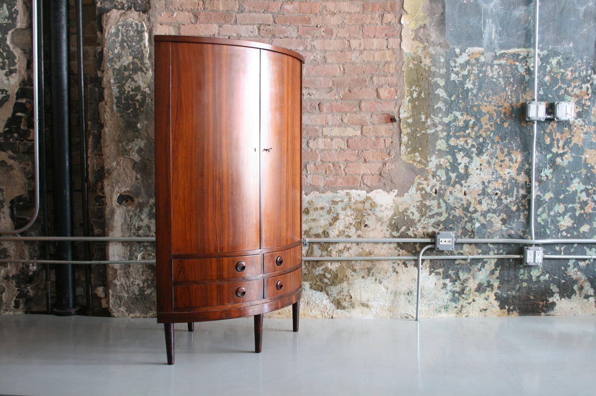 Danish Mid-Century Modern rosewood corner cabinet having swing out drawers and shelves. Excellent condition.