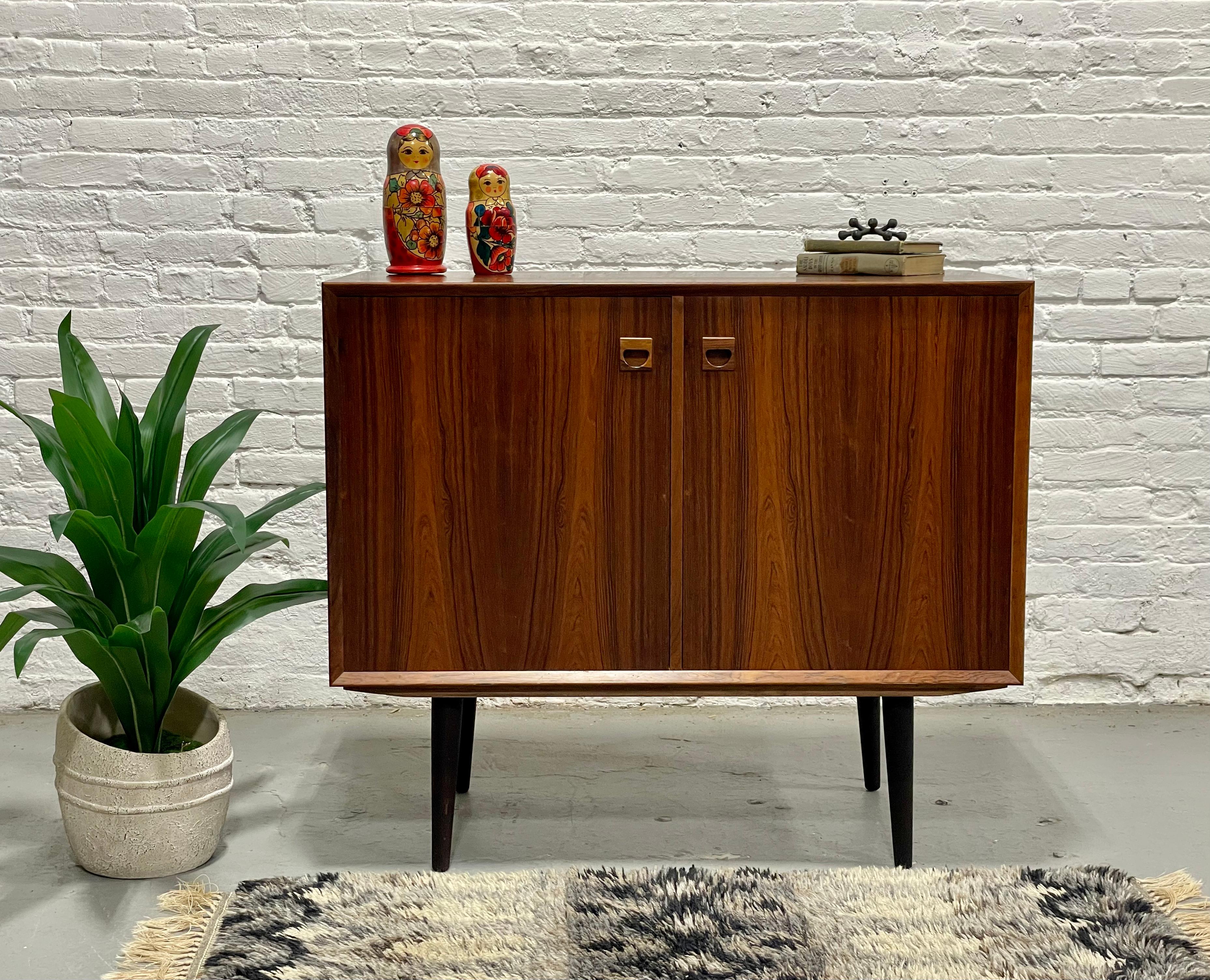 Danish Mid Century Modern Rosewood Jr. Credenza / Storage Cabinet, c. 1960's.  This streamlined cabinet offers a vast amount of storage space in its deep and spacious interior. Two adjustable shelves allow for flexible storage.  Constructed in