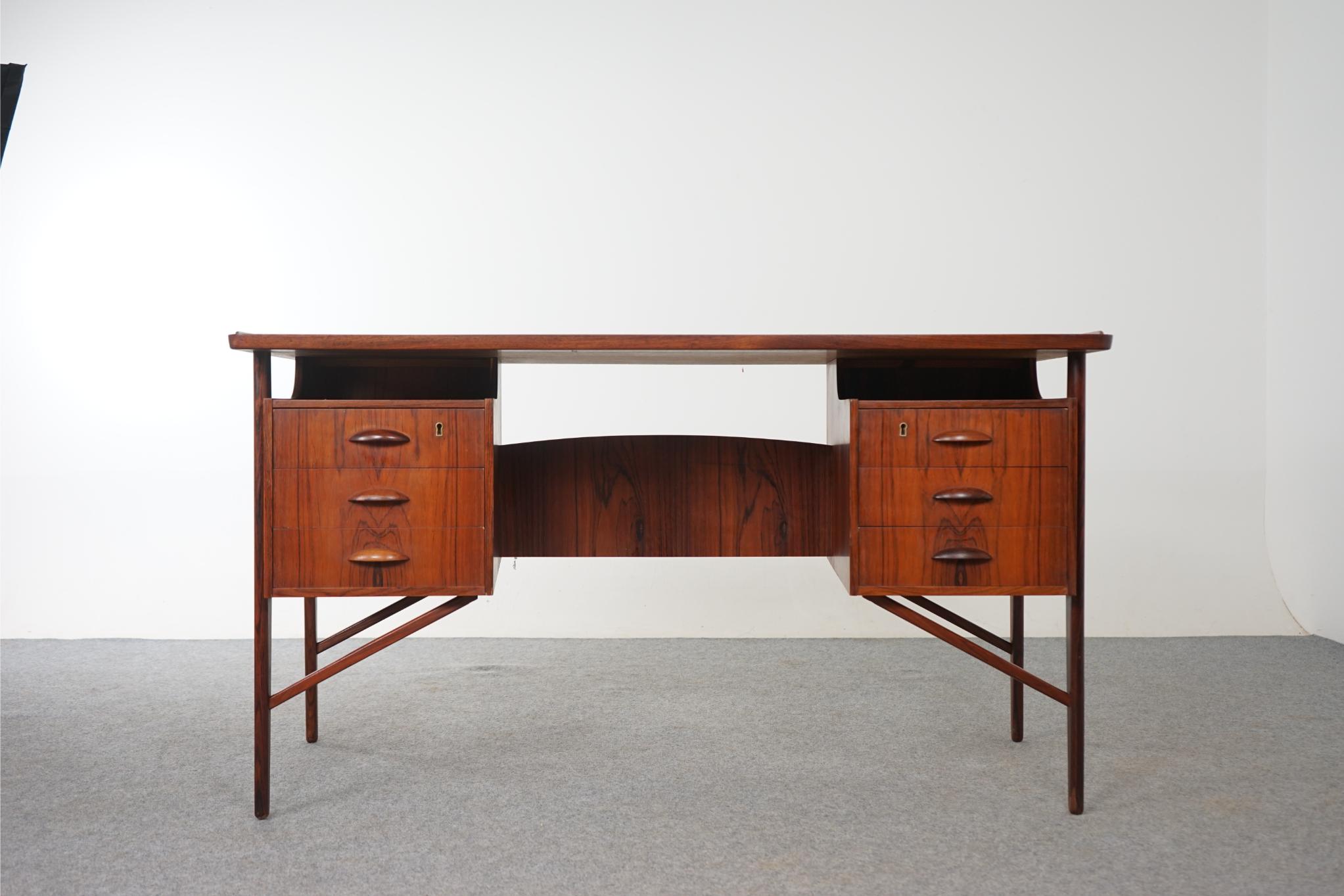 Teak writing desk by Ib Kofod Larsen for Faarup, circa 1960's. Incredibly built writing desk is finished on both sides, if placed in the center of a room it will look fantastic from every angle! Stunning hand formed solid wood drawer pulls offer