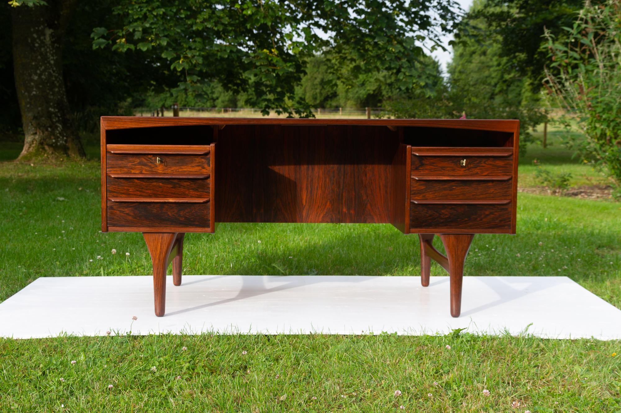 Danish Mid-Century Modern Rosewood Desk by Valdemar Mortensen, 1960s.
High end freestanding executive Rosewood desk by Danish master carpenter Valdemar Mortensen from Odense, Denmark.
Table top with arched trim and book matched veneer.
Front with