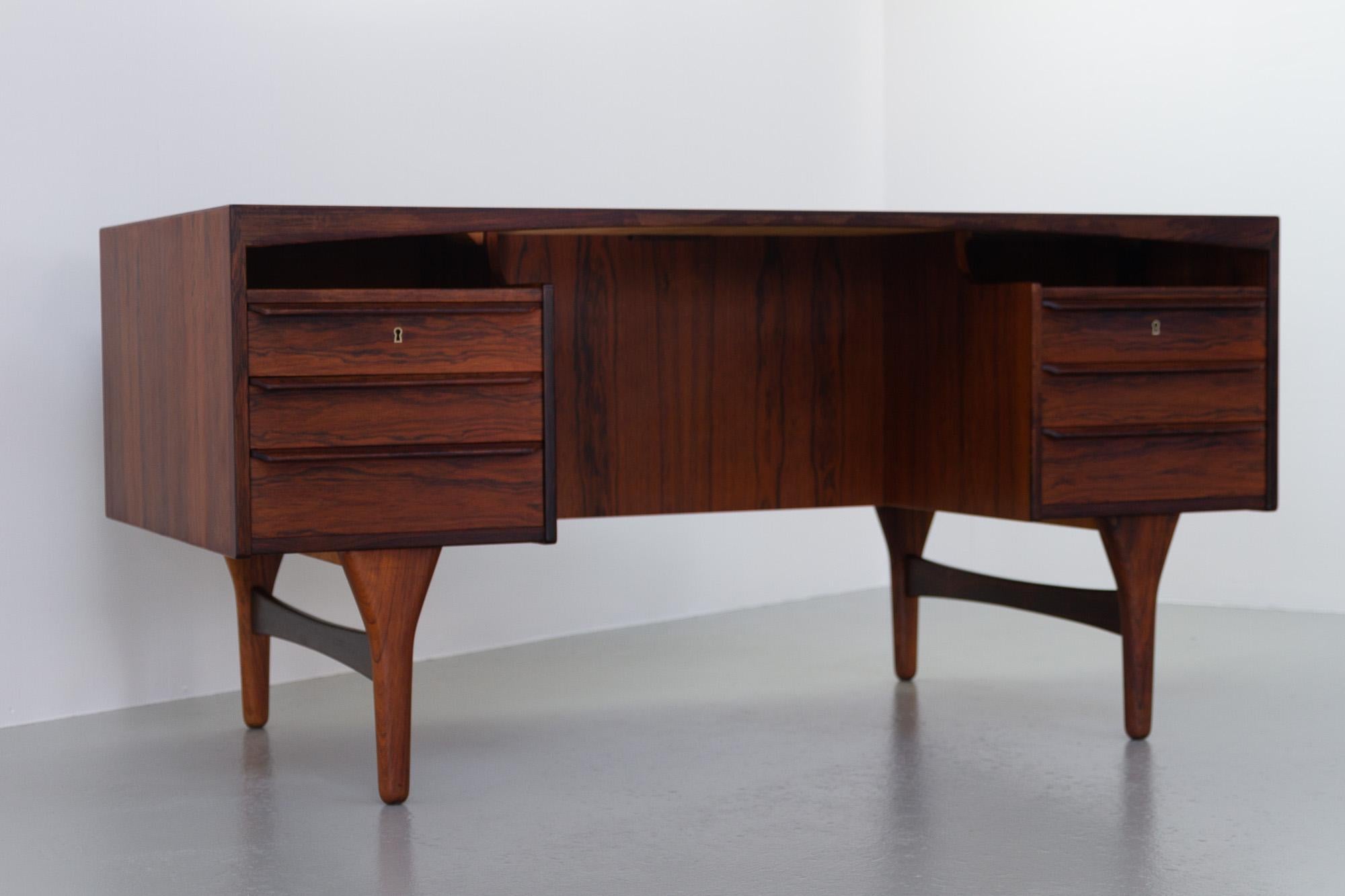 Danish Mid-Century Modern Rosewood desk by Valdemar Mortensen, 1960s.
High-end freestanding executive Rosewood writing table by Danish master carpenter Valdemar Mortensen from Odense, Denmark.
Table top with arched trim and book matched