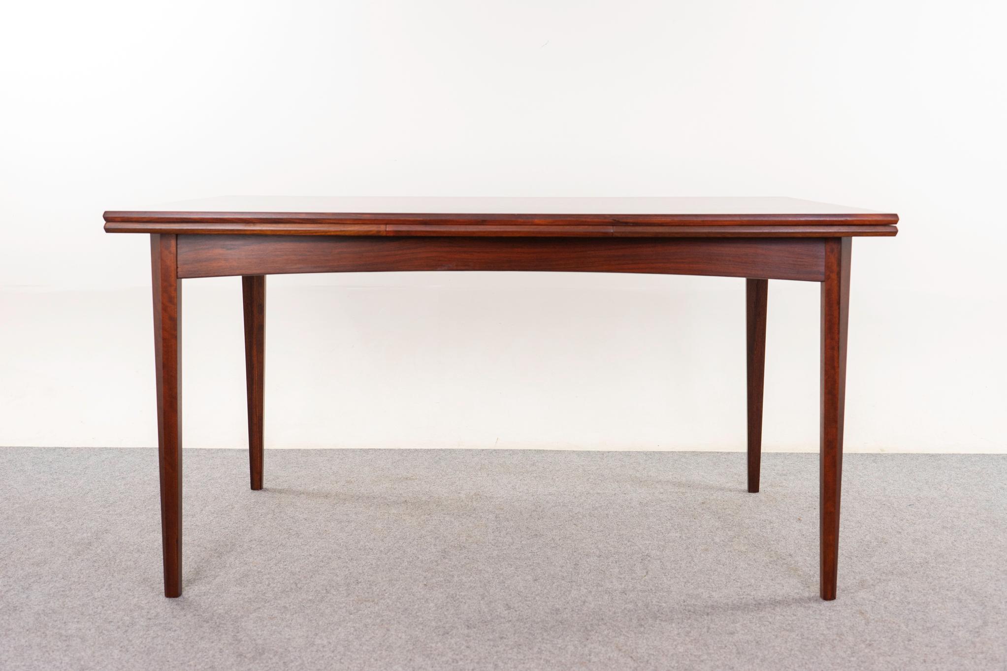 Table de salle à manger moderne danoise en bois de rose, vers les années 1960. Le plateau de la table est encadré par des bordures en bois massif, tandis que les panneaux centraux présentent un placage hautement figuré dont le grain est assorti à