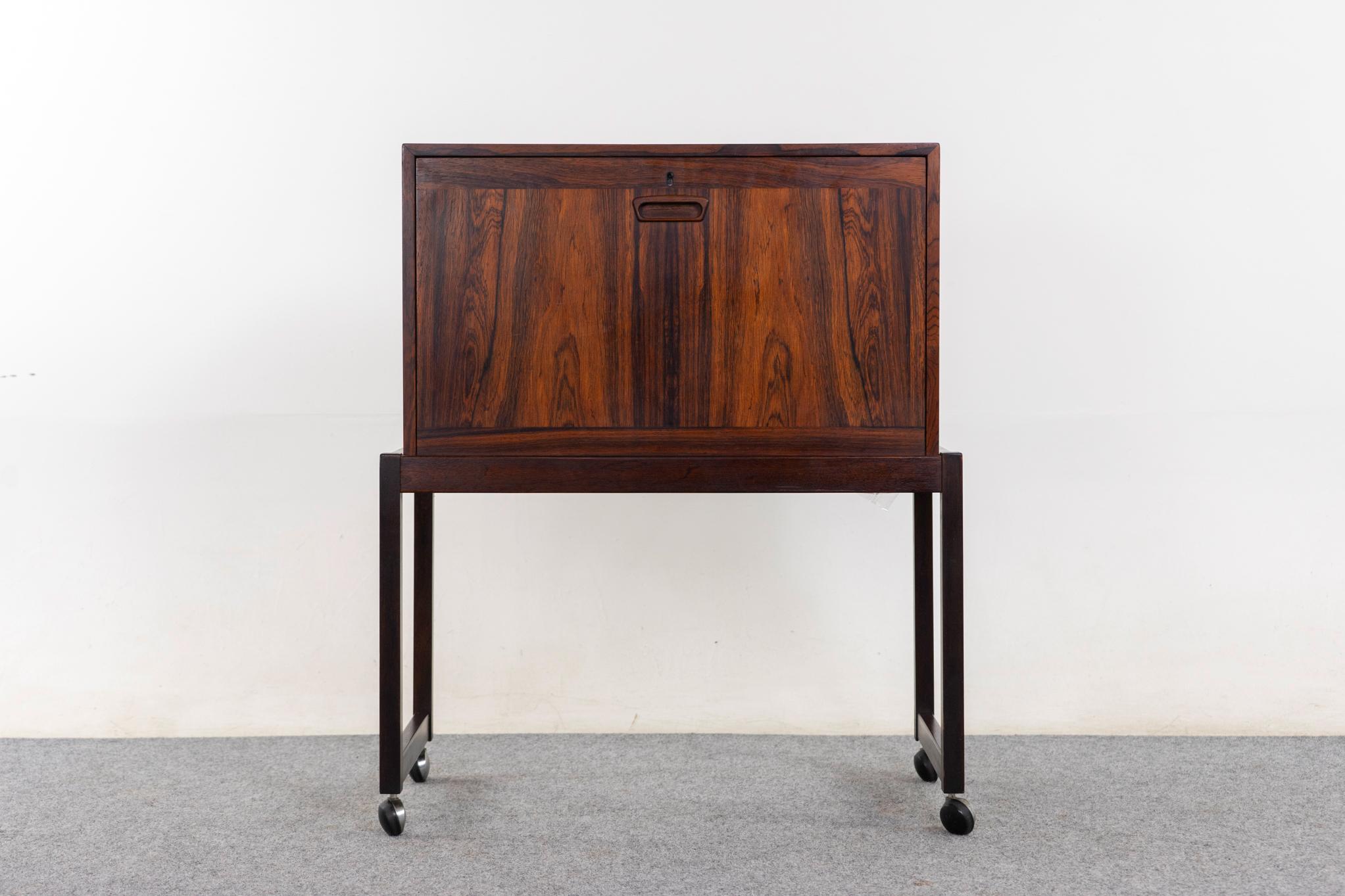 Barra danesa de palisandro, hacia 1960. ¡Preciosa chapa de madera veteada por todas partes! Frontal abatible, estante extraíble y elegante base con ruedas originales. Algo de desgaste en la superficie superior.